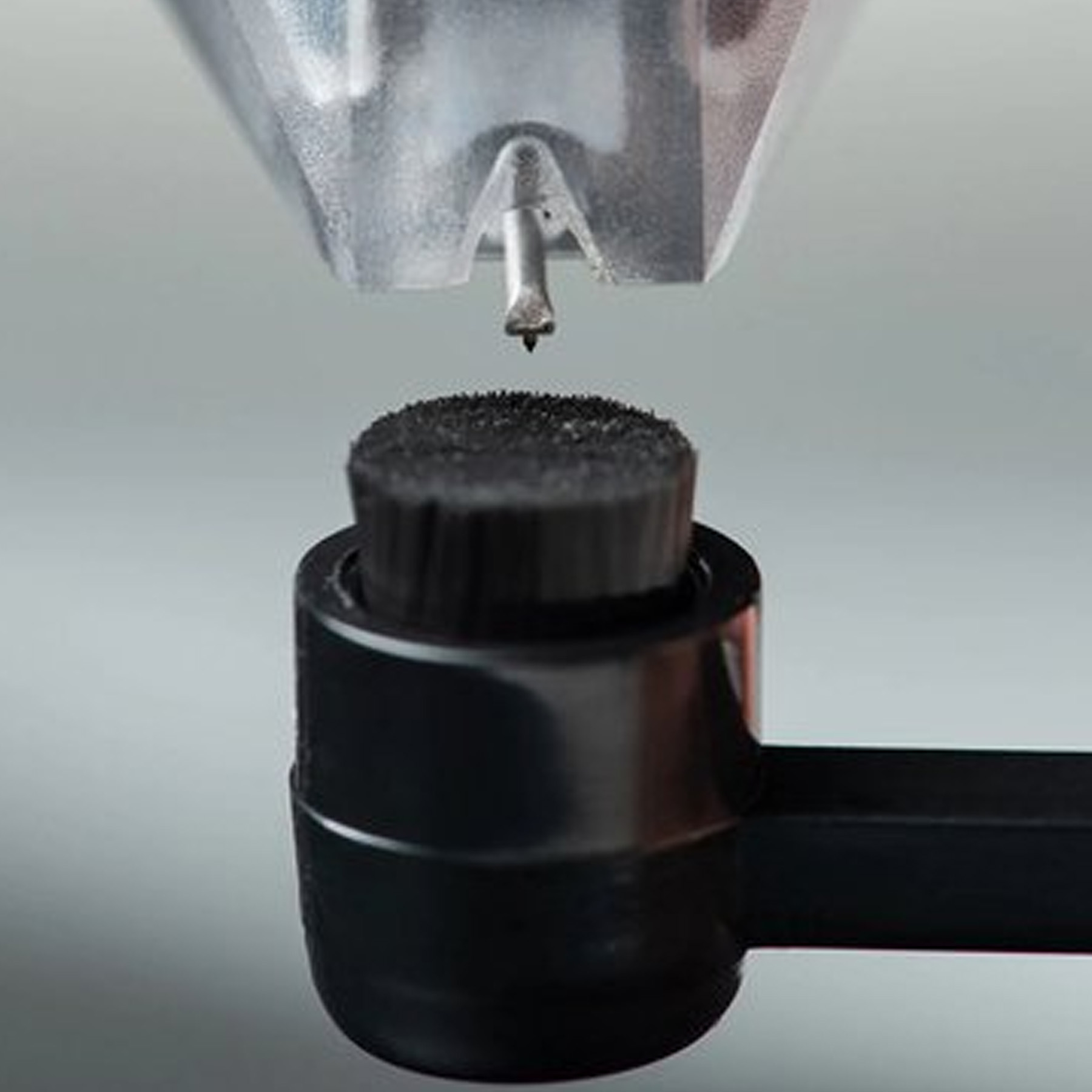 Igła ze szczoteczką czyszcząca końcówkę rysika gramofonu. Ostrość skupiona jest na końcówce rysika.