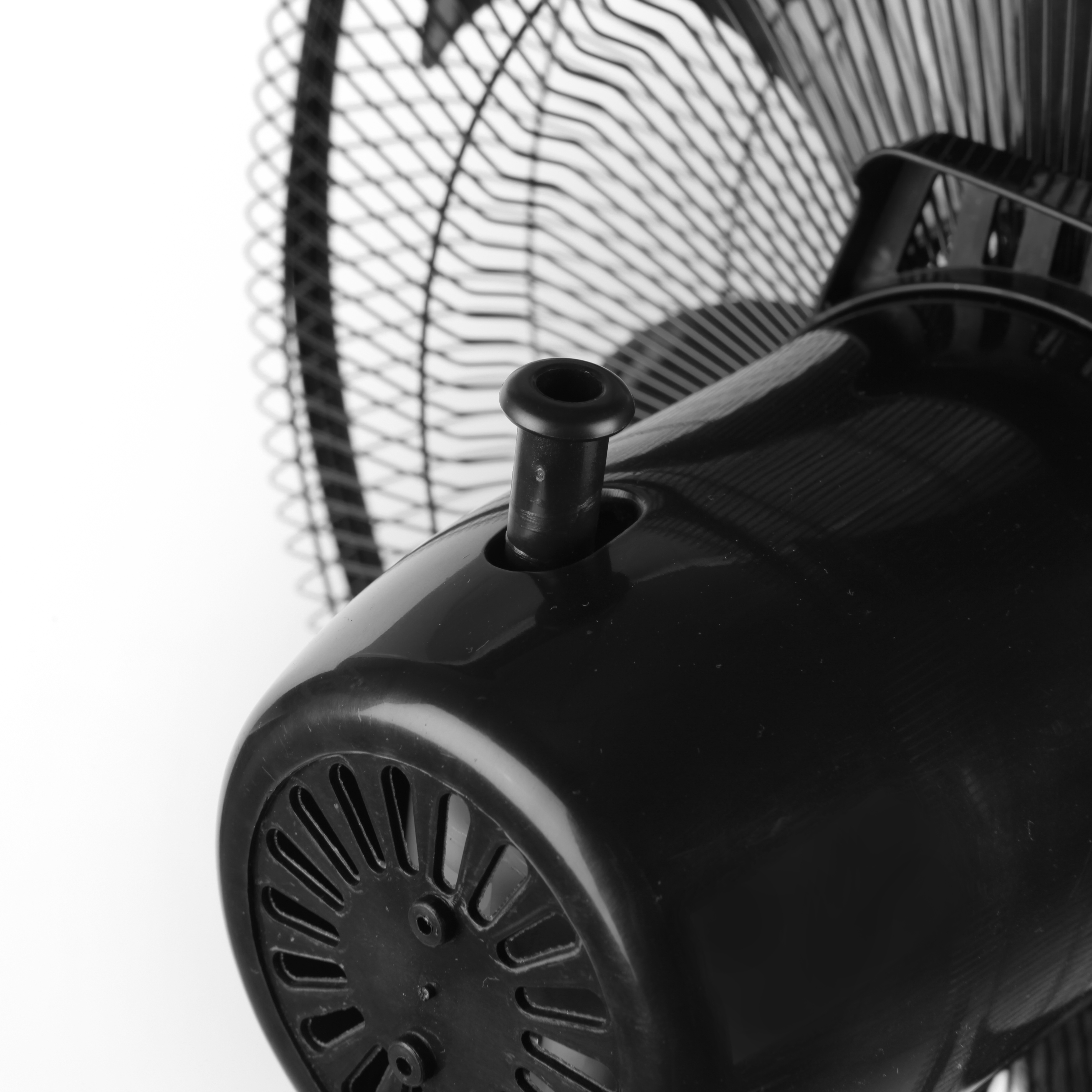 Zbliżenie silnika i łopatek czarnego wentylatora na białym tle.