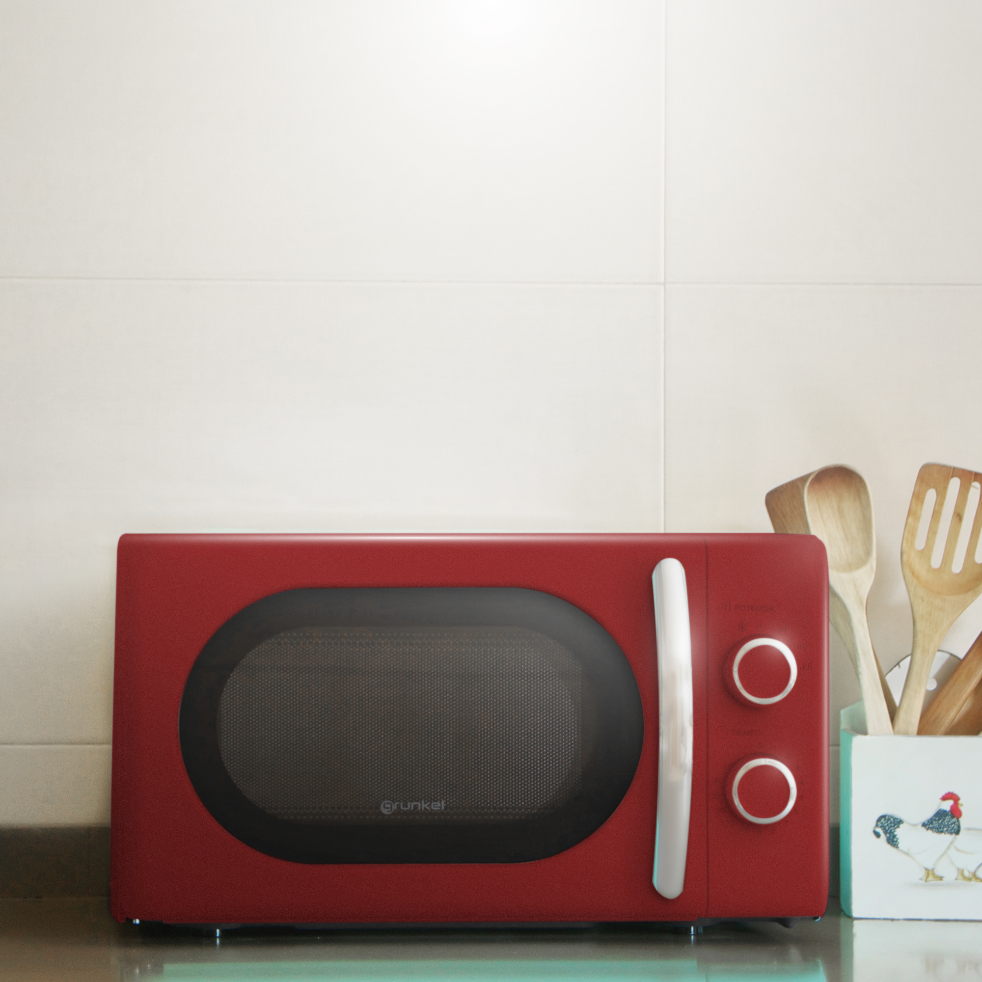 Horno microondas rojo sobre encimera. Ambiente de cocina con utensilios de madera cerca.