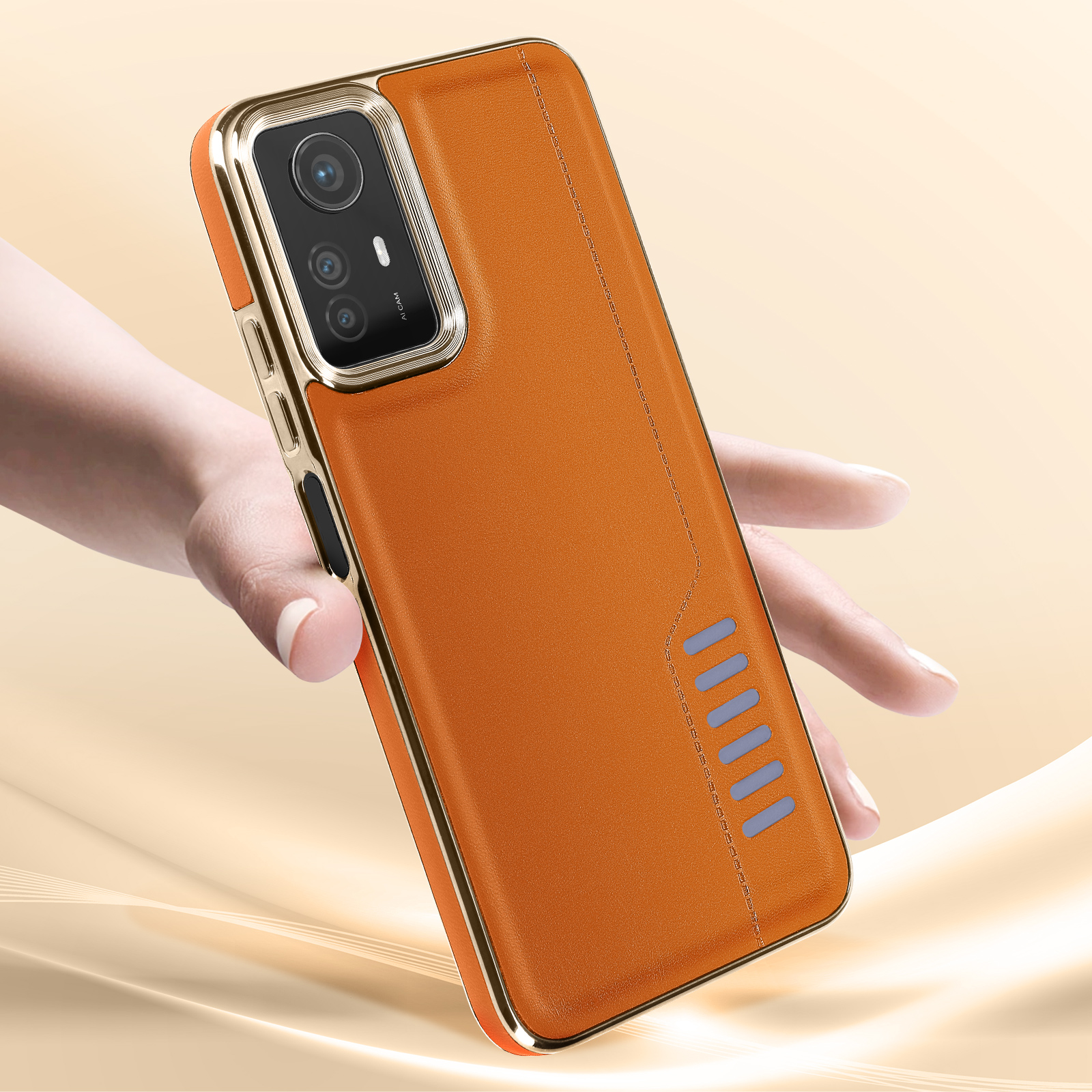 Mano che tiene un telefono in una custodia di pelle arancione con cornice dorata.