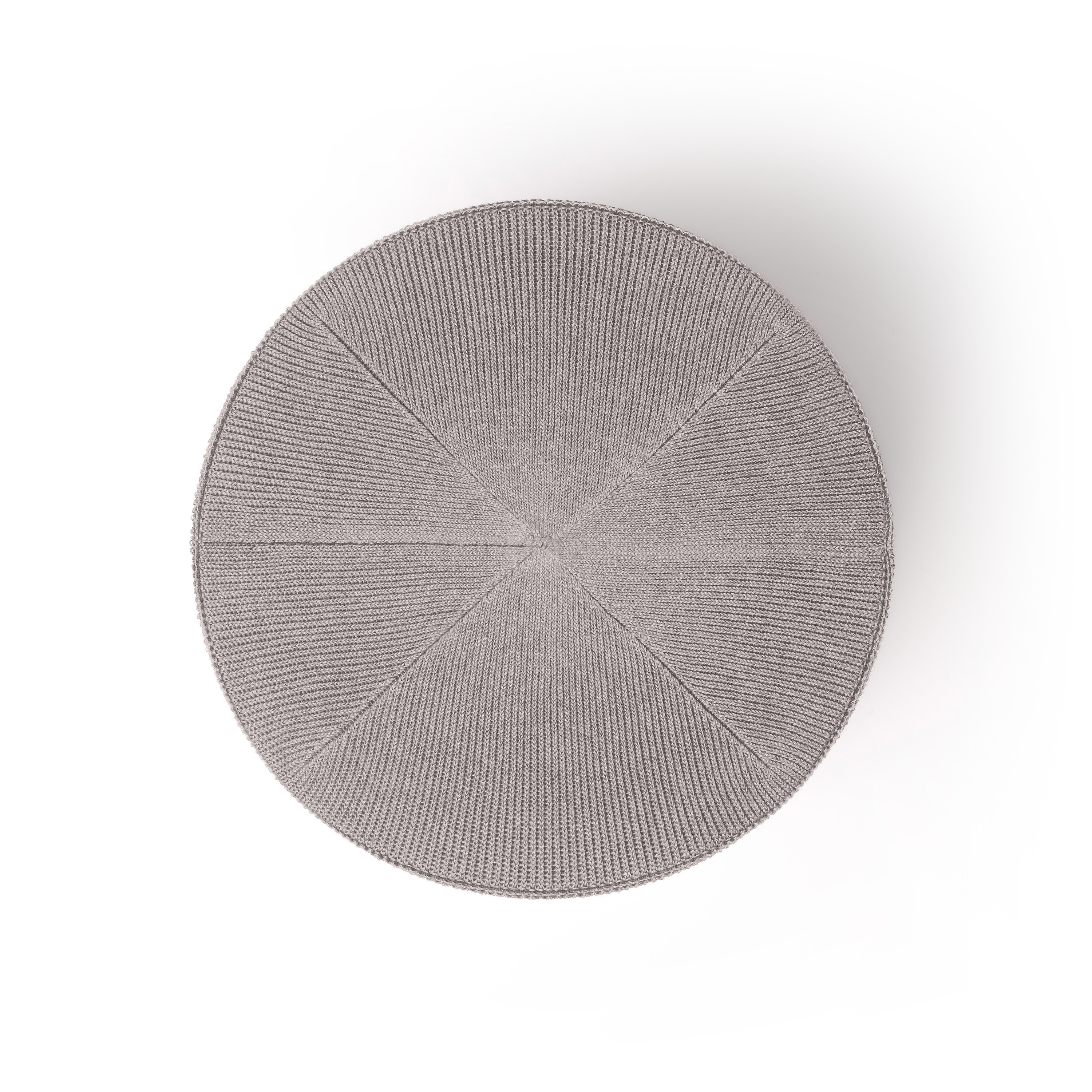 Vue de dessus d'un bonnet circulaire en tricot gris clair. C'est un cercle plat avec une texture côtelée.