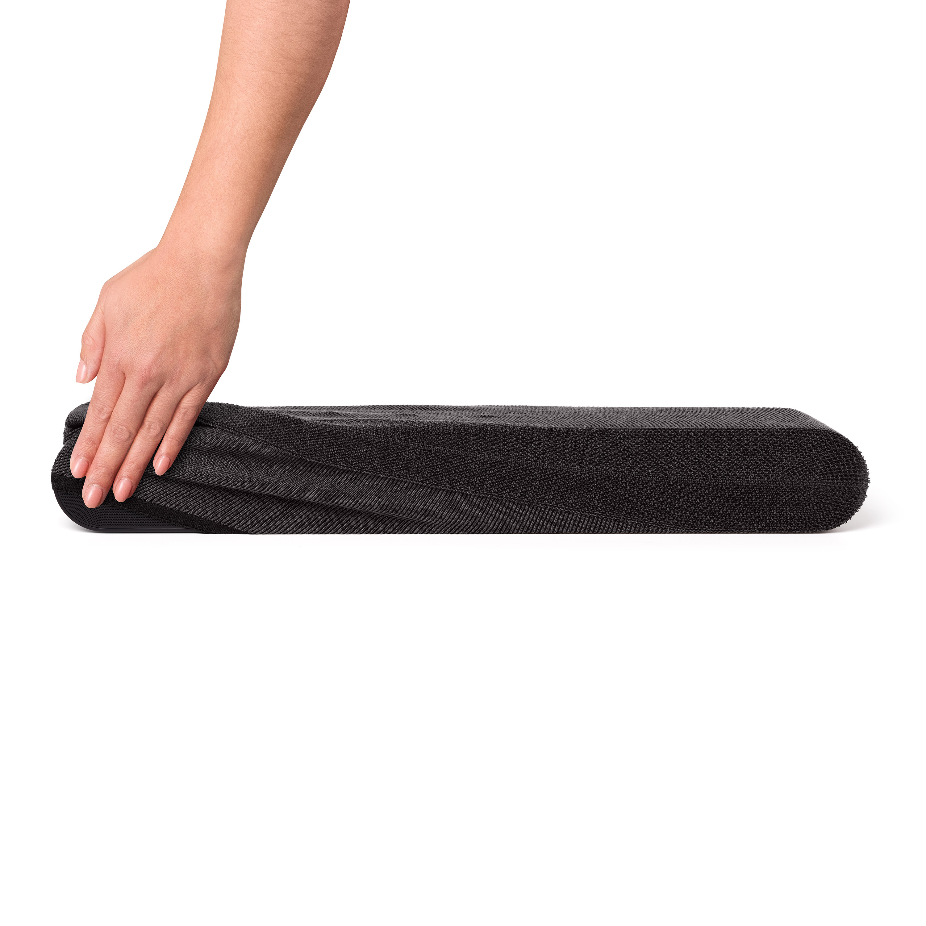 Une main touche un rouleau de mousse noir plié.