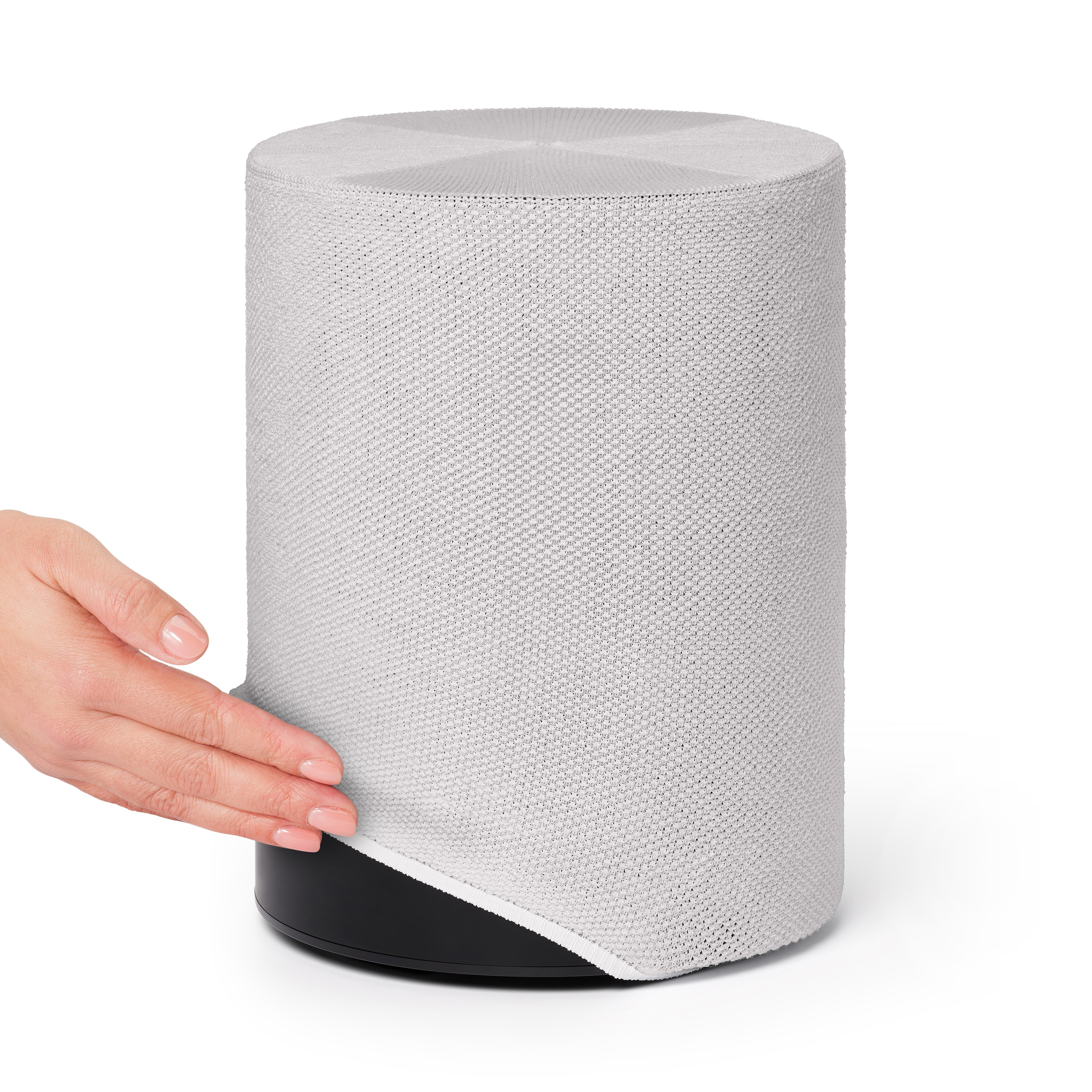 Une main tenant un couvercle de haut-parleur blanc. Le haut-parleur est noir, le couvercle est blanc et le fond est blanc.