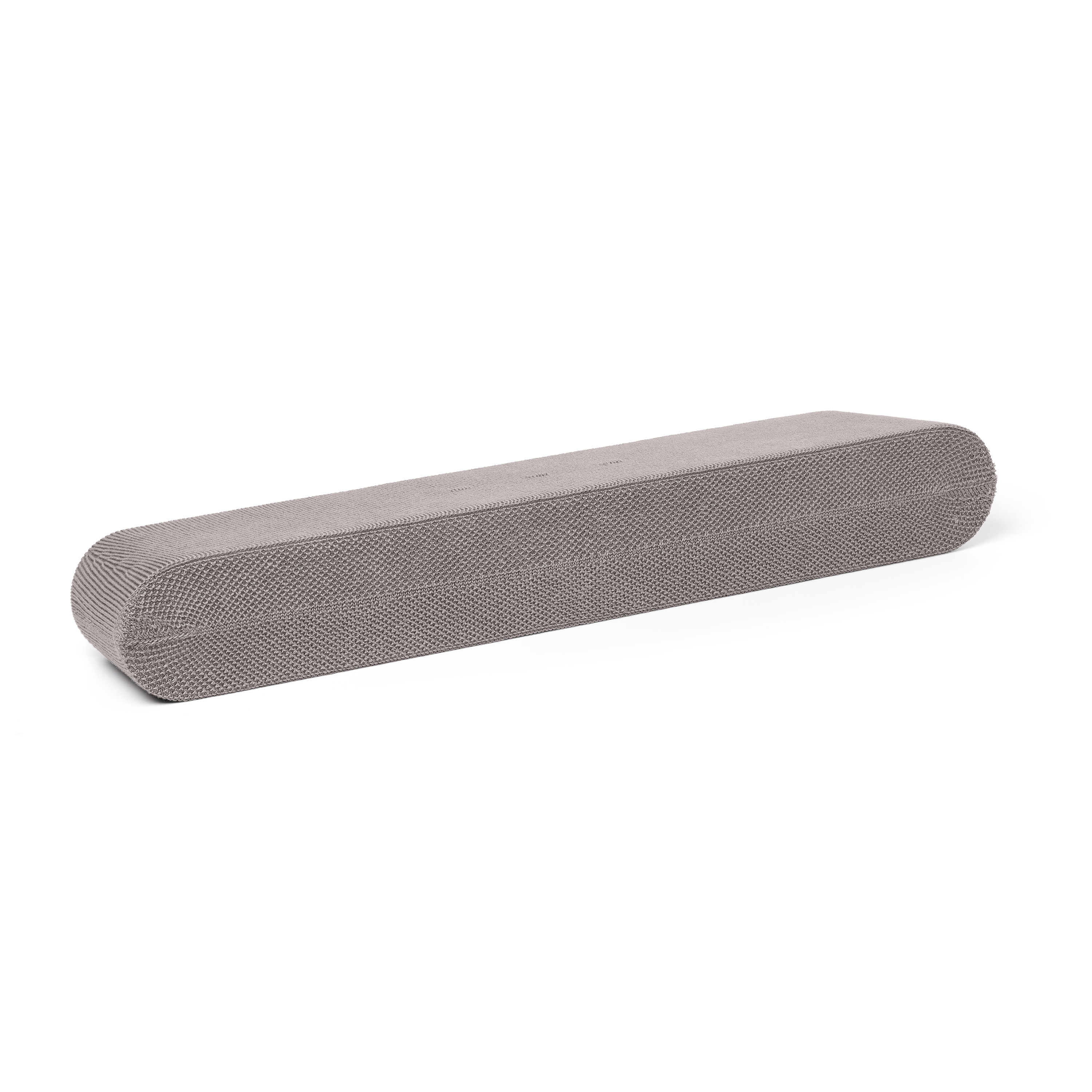 Banc oblong gris rembourré sur fond blanc. Le banc a une surface texturée.