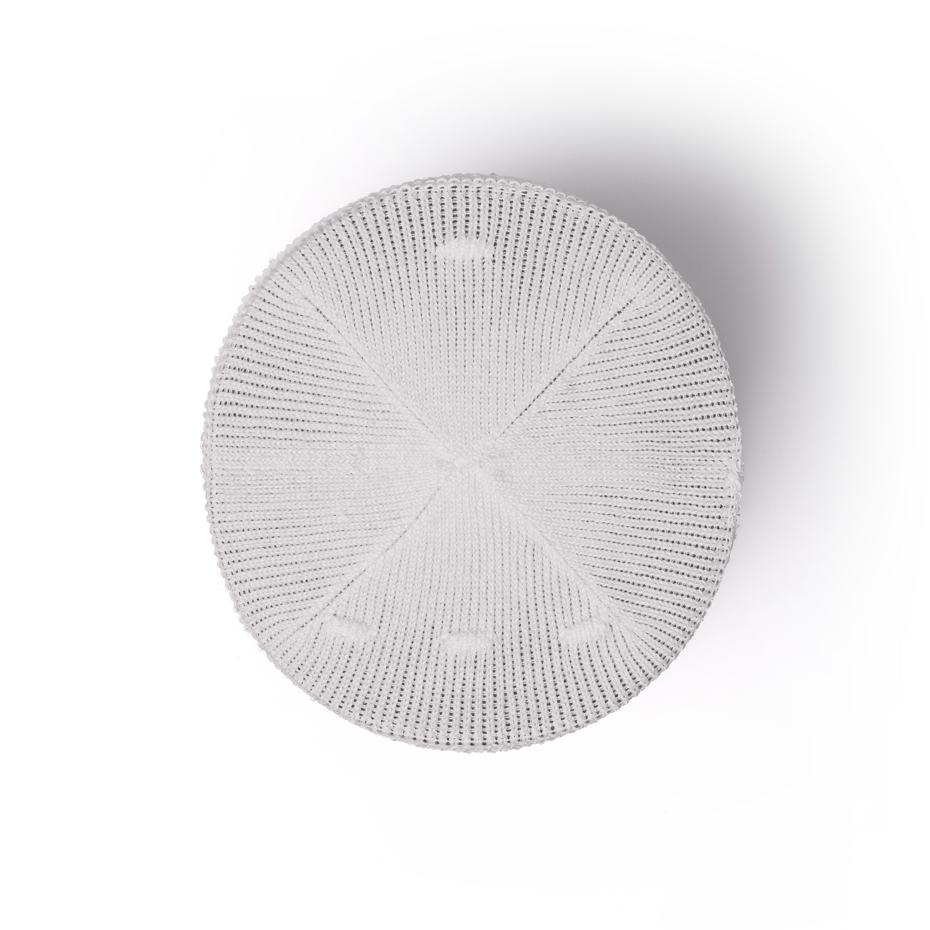 Een witte, cirkelvormige pet met kleine gaatjes in een radiaal patroon.