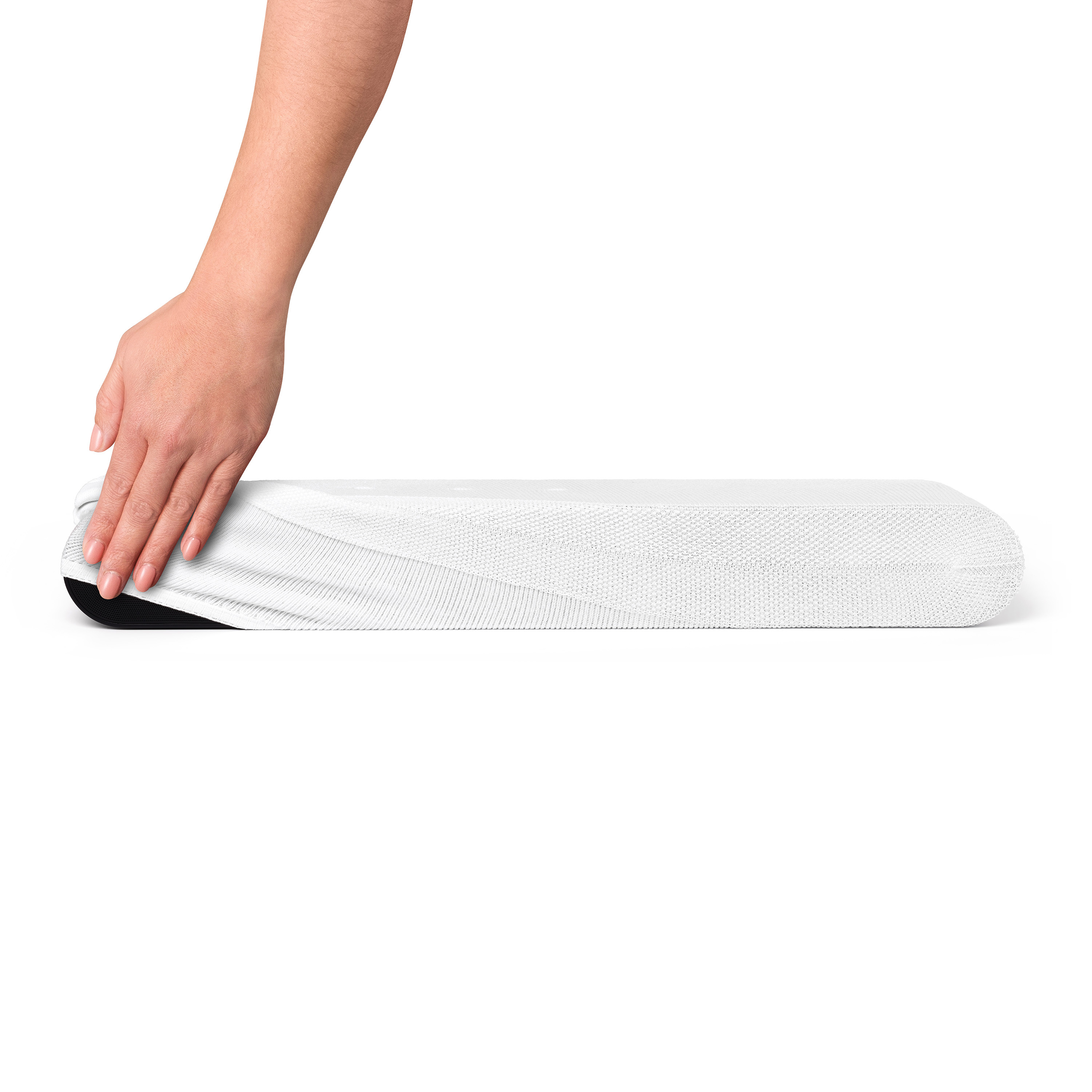 Main plaçant une housse blanche texturée sur un haut-parleur long et blanc.