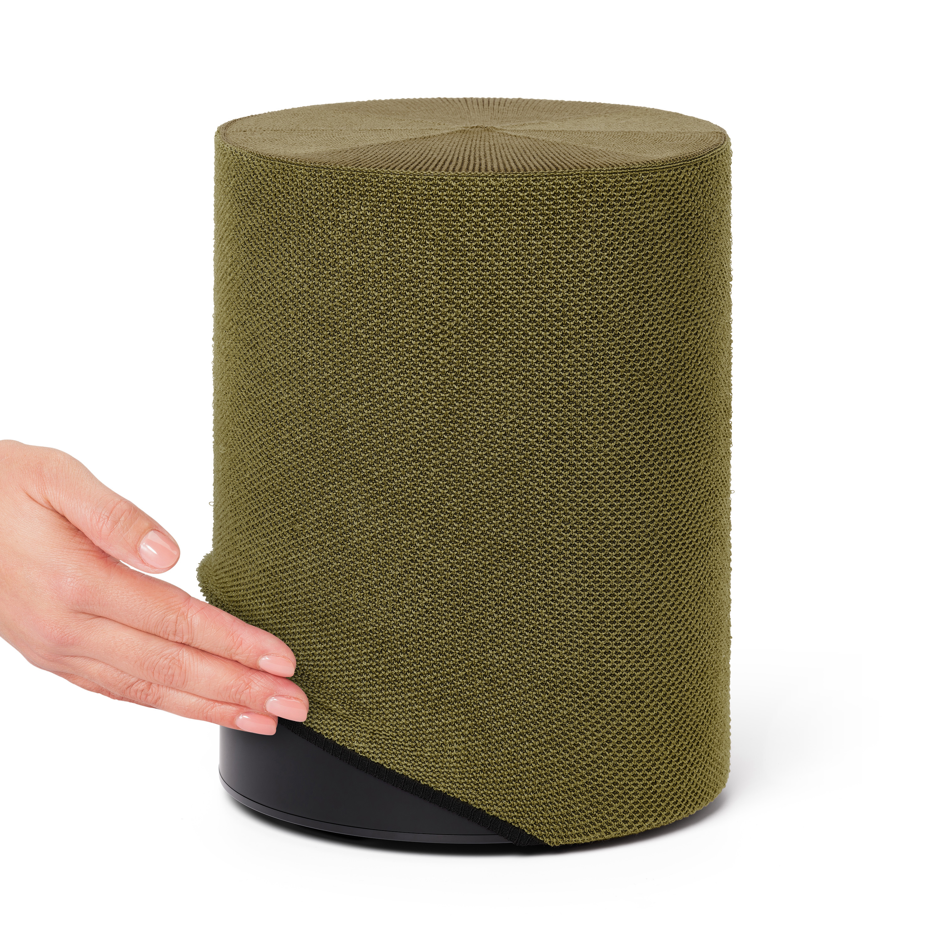 Main touchant tissu vert olive sur un cylindre noir.
