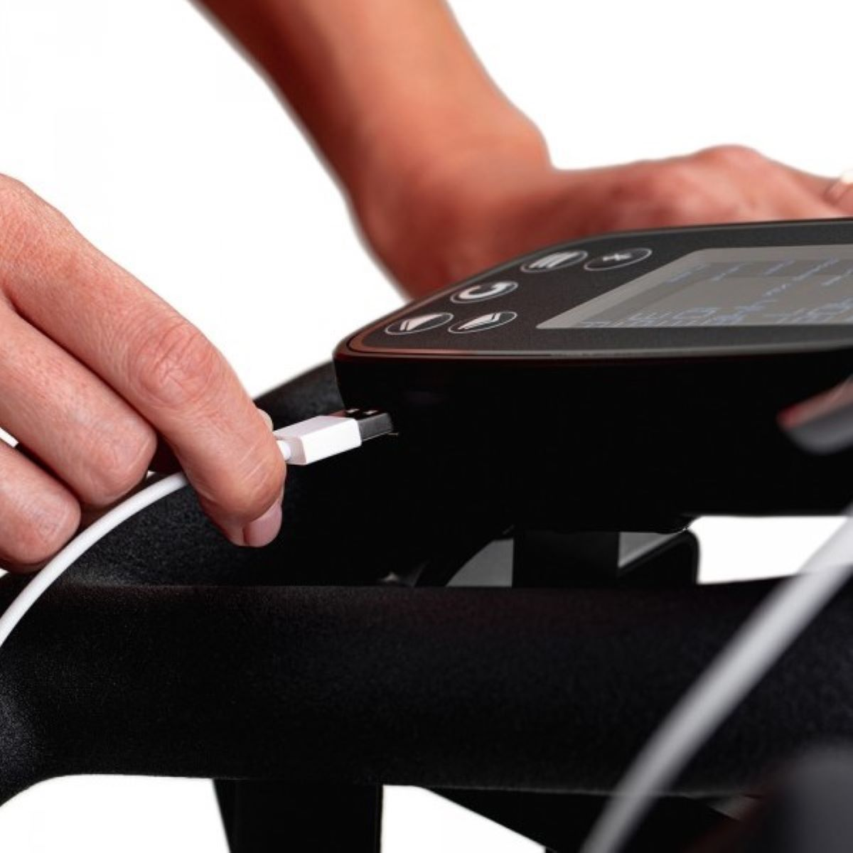 Dłoń podłączająca biały kabel USB do czarnego urządzenia, prawdopodobnie trackera fitness.