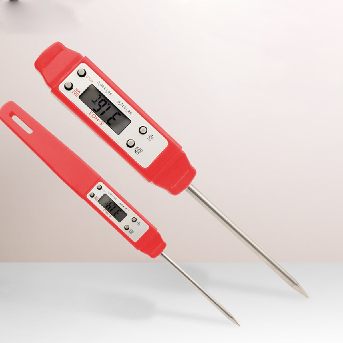 Zwei rote Digitalthermometer auf hellem Hintergrund. Eines ist größer als das andere.