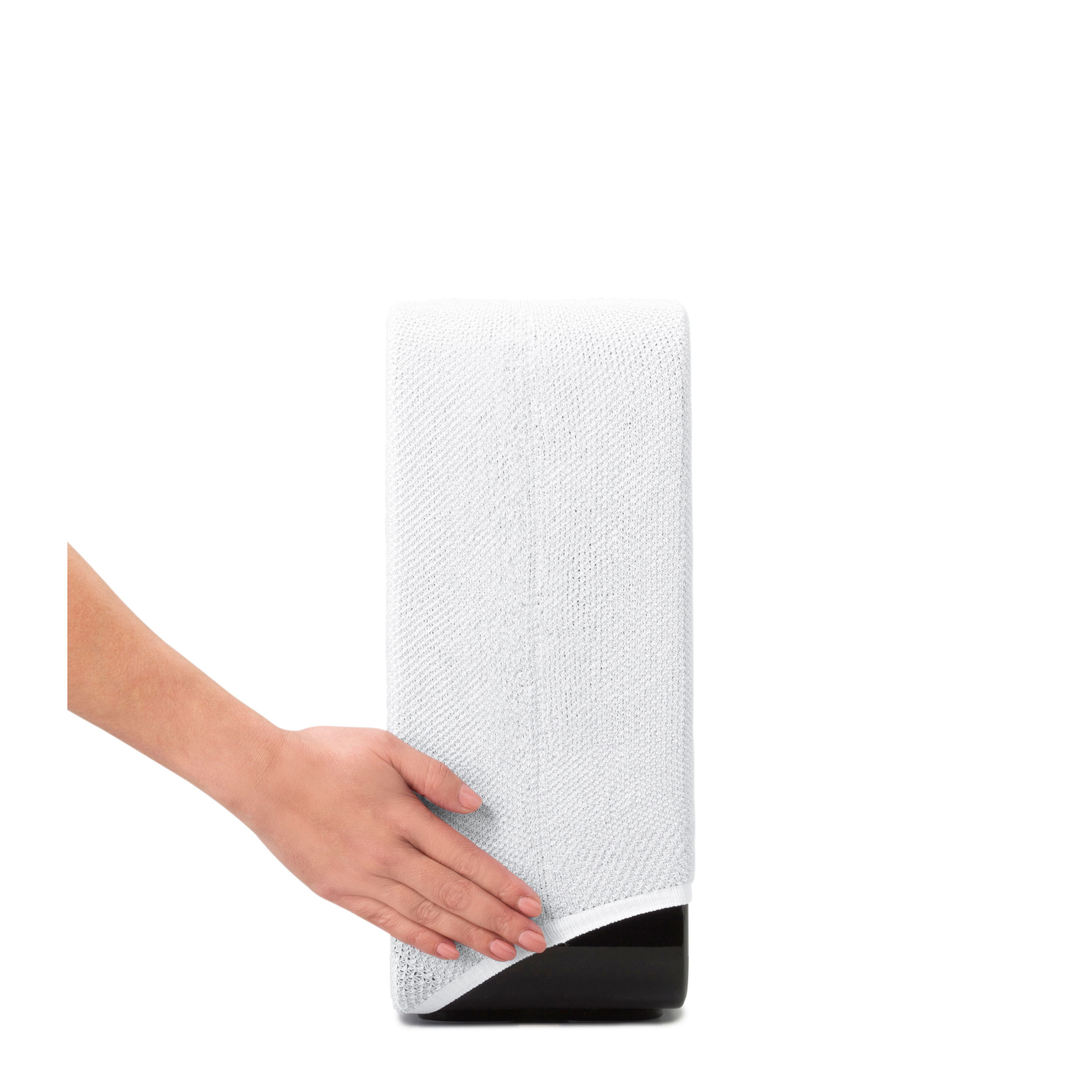 Un objet cylindrique blanc est tenu par la main d'une femme. L'objet est sur une base noire.