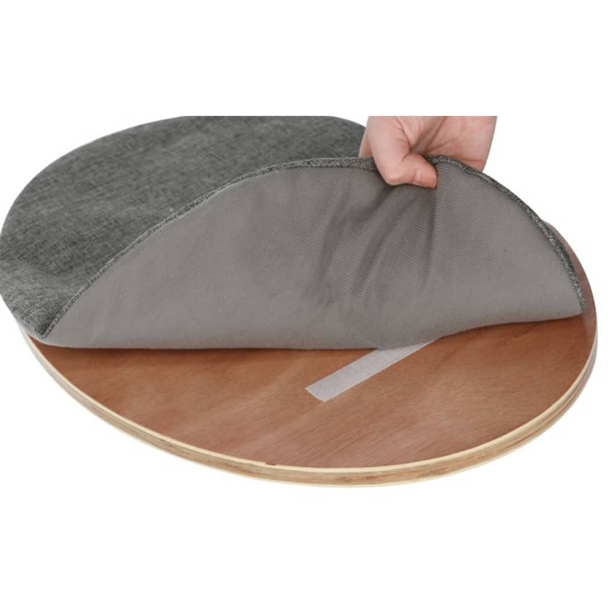Eine Hand hebt die graue Stoffabdeckung einer runden Holzplatte an.