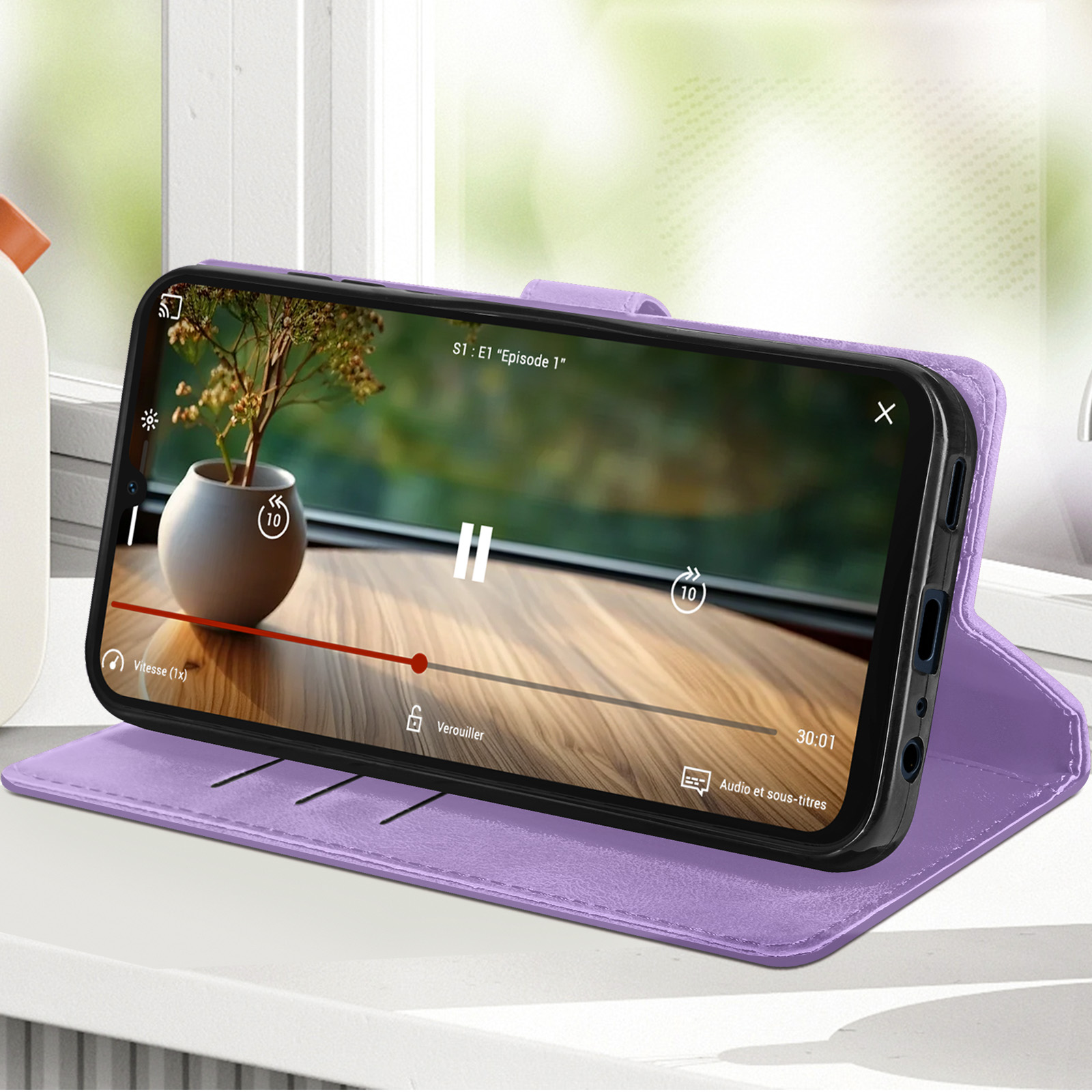Custodia per telefono viola con video. Tavolo in legno, vista finestra sullo sfondo.