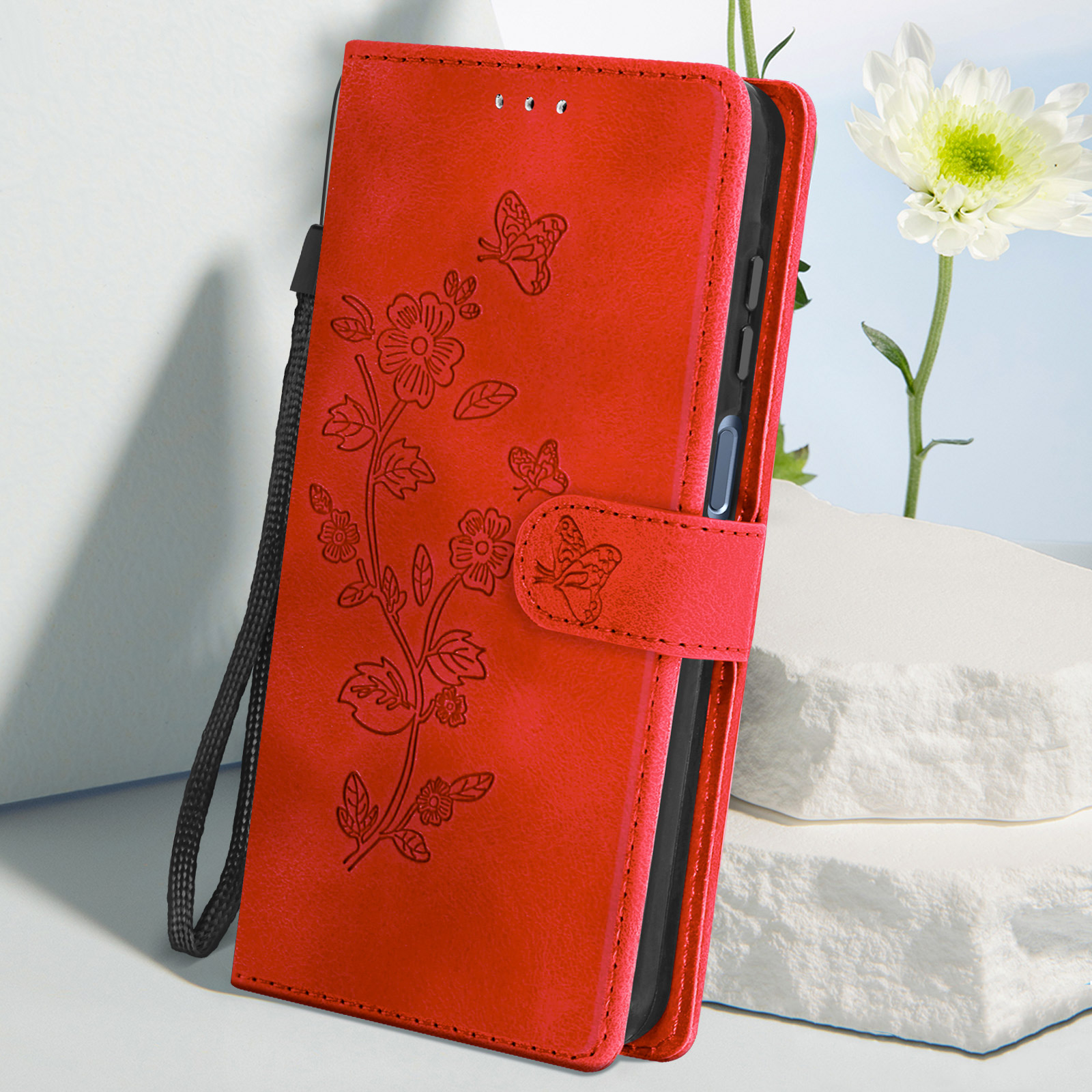 Custodia per telefono rossa con design floreale e farfalle, un fiore bianco è visibile.