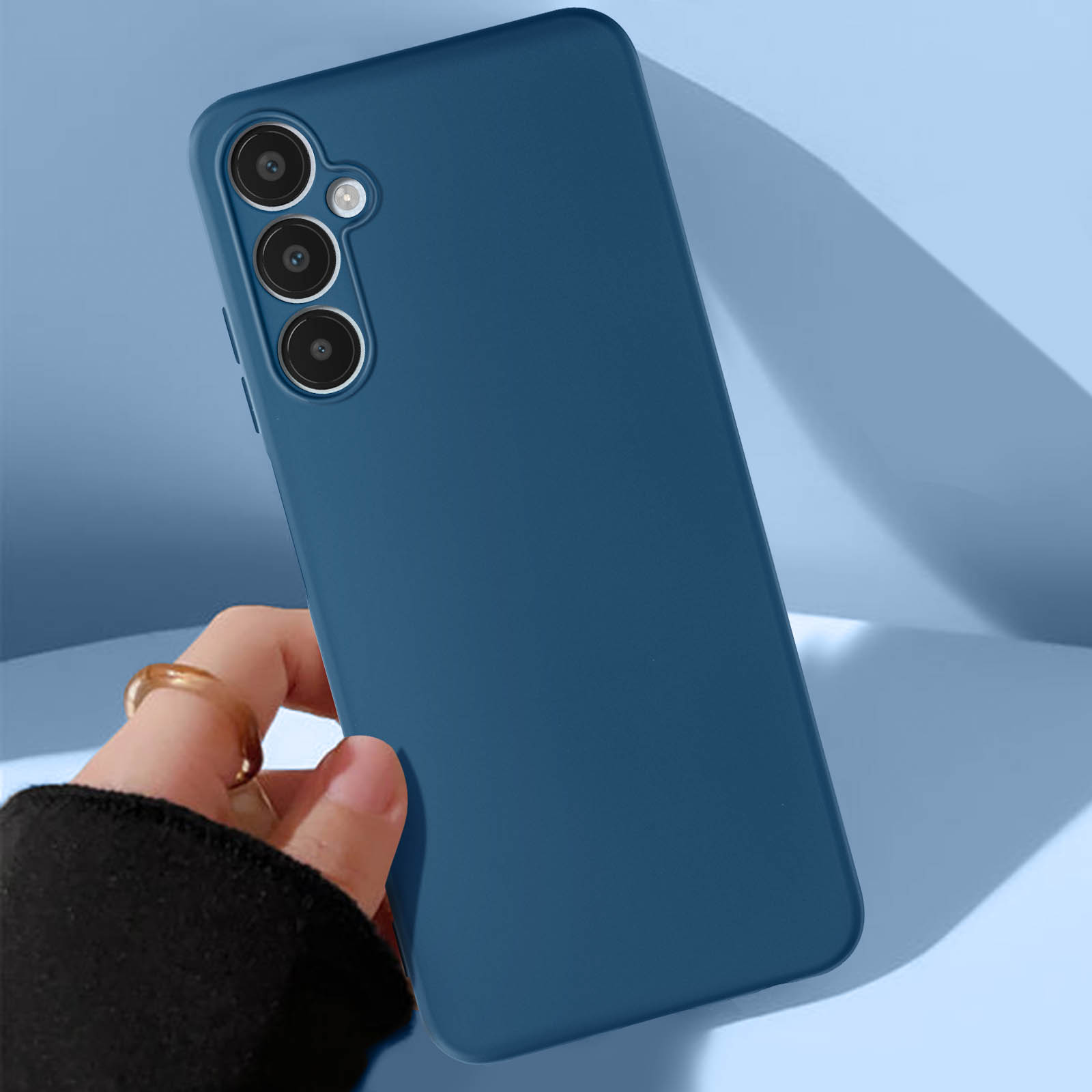 Una mano sosteniendo una funda azul. El teléfono tiene tres cámaras.