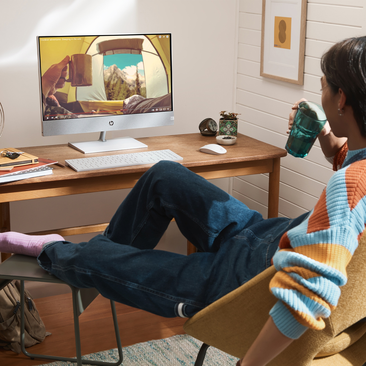 Kobieta siedzi na krześle i patrzy na ekran komputera. Na biurku jest monitor, klawiatura i mysz.