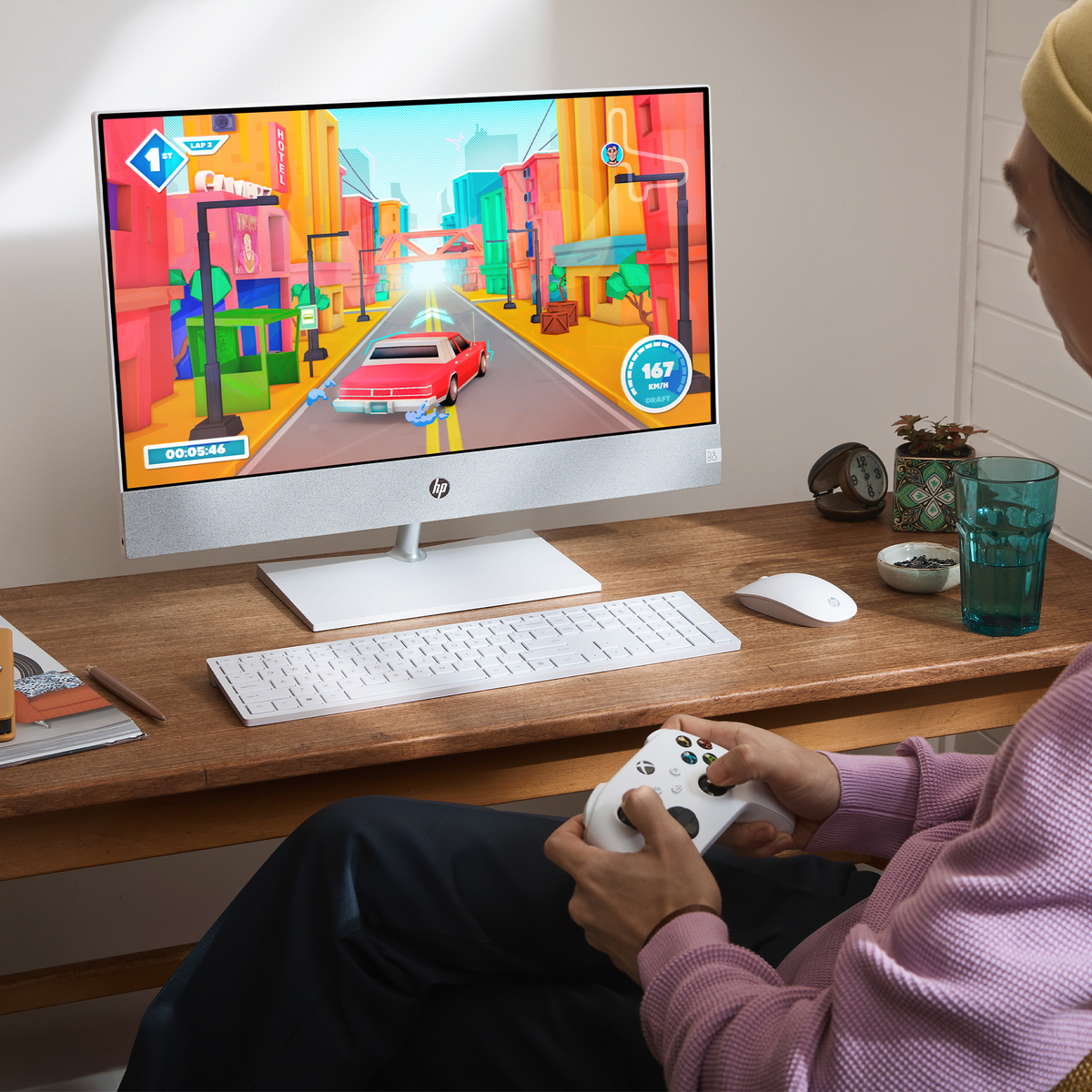 Osoba gra w grę wyścigową na komputerze stacjonarnym z kontrolerem.