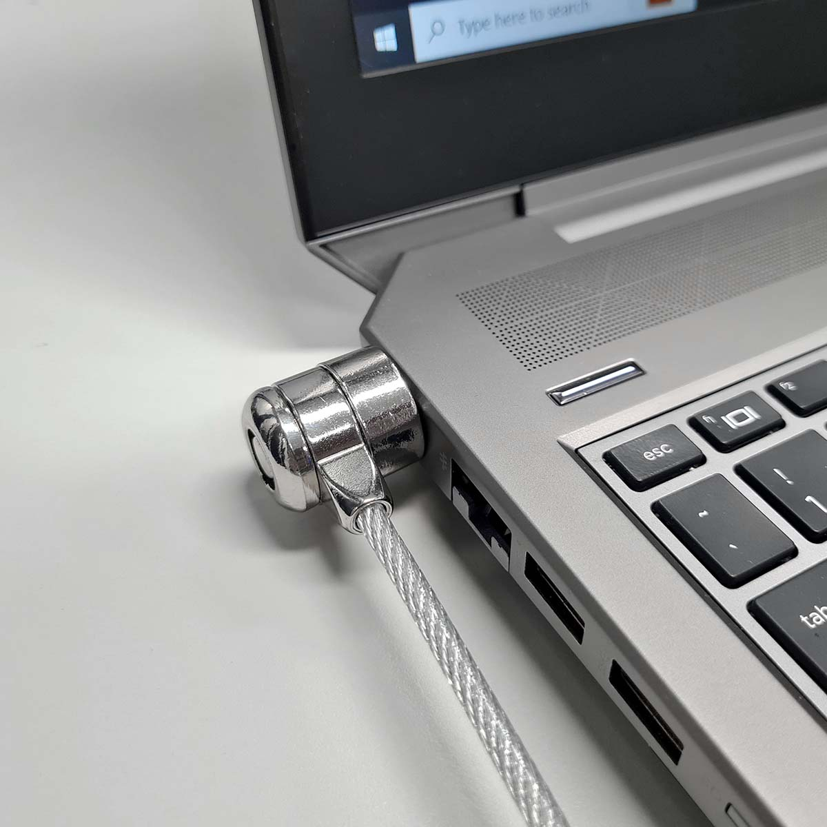 Laptop con lucchetto di sicurezza collegato. Il lucchetto è argentato e collegato tramite un cavo.