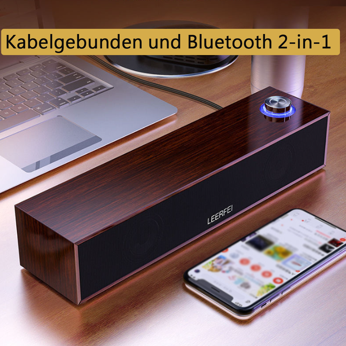 Altavoz con un teléfono, portátil y accesorios en una mesa.