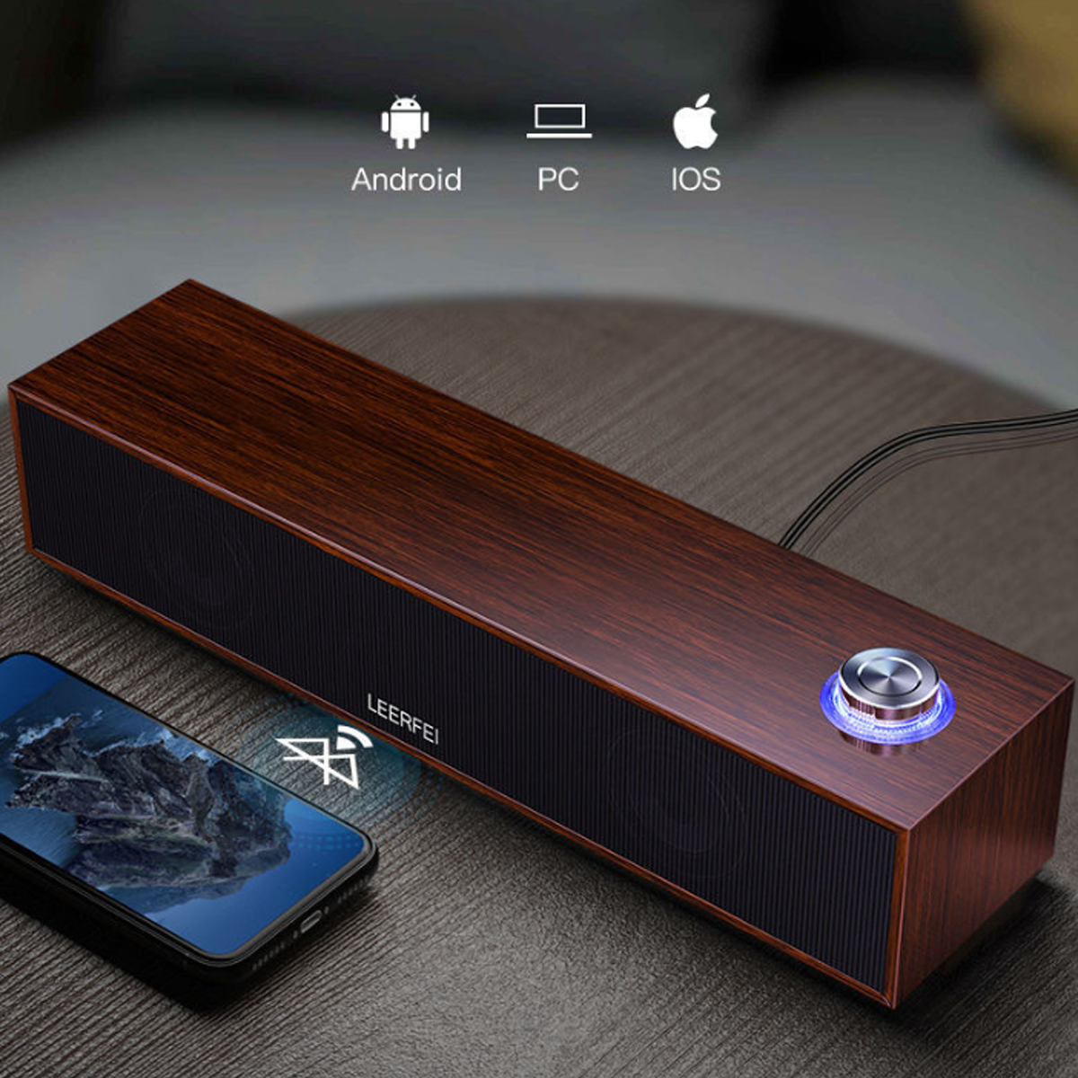 Un altavoz de madera con una parte frontal de malla negra, un teléfono e iconos de Android, PC e iOS.