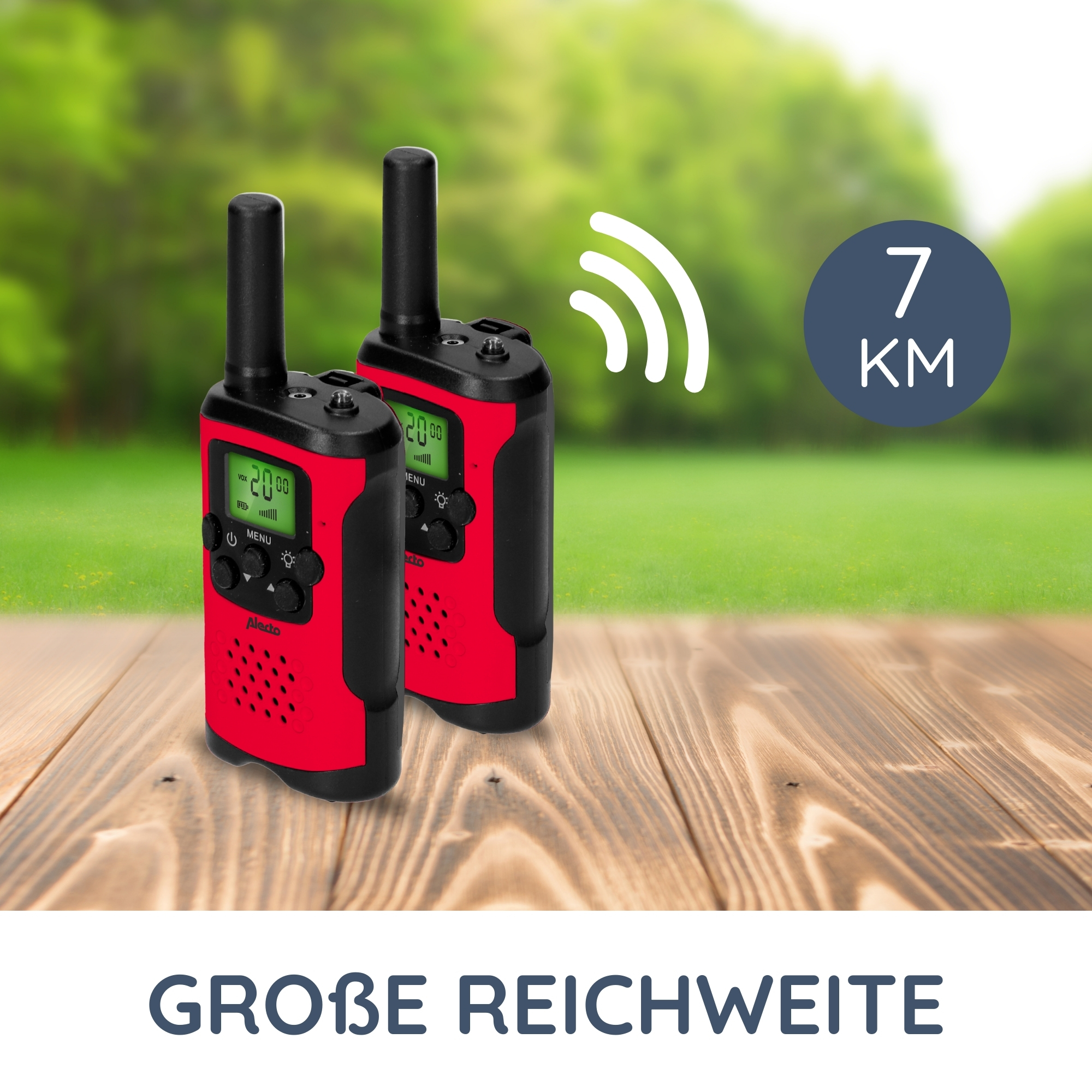 Dwa czerwone krótkofalówki z czarnymi akcentami. Znajdują się na drewnianej powierzchni z zielonym tłem.