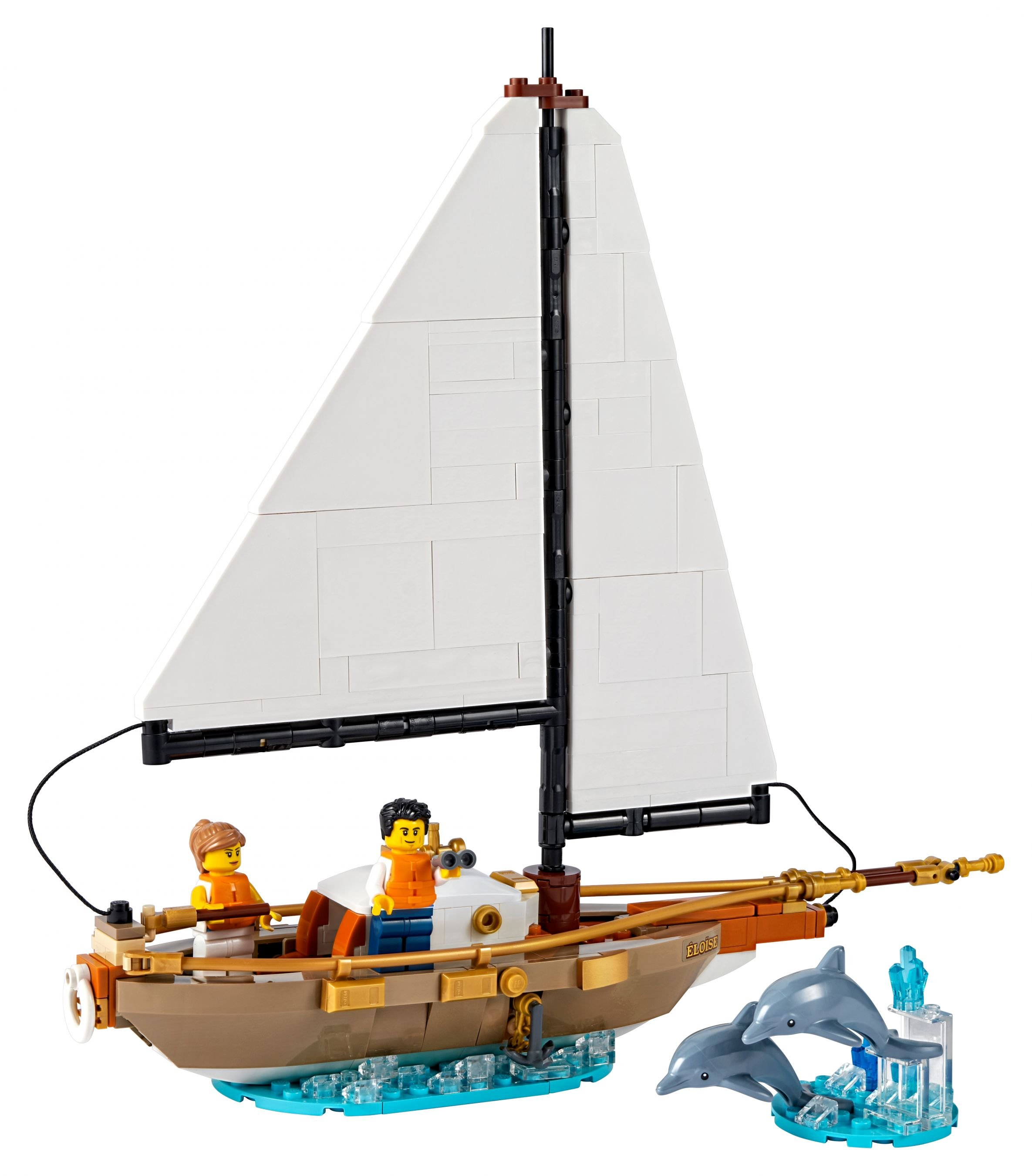 Spielzeugsegelschiff mit zwei Figuren, Segel und zwei Delfinen. Weißer Hintergrund.