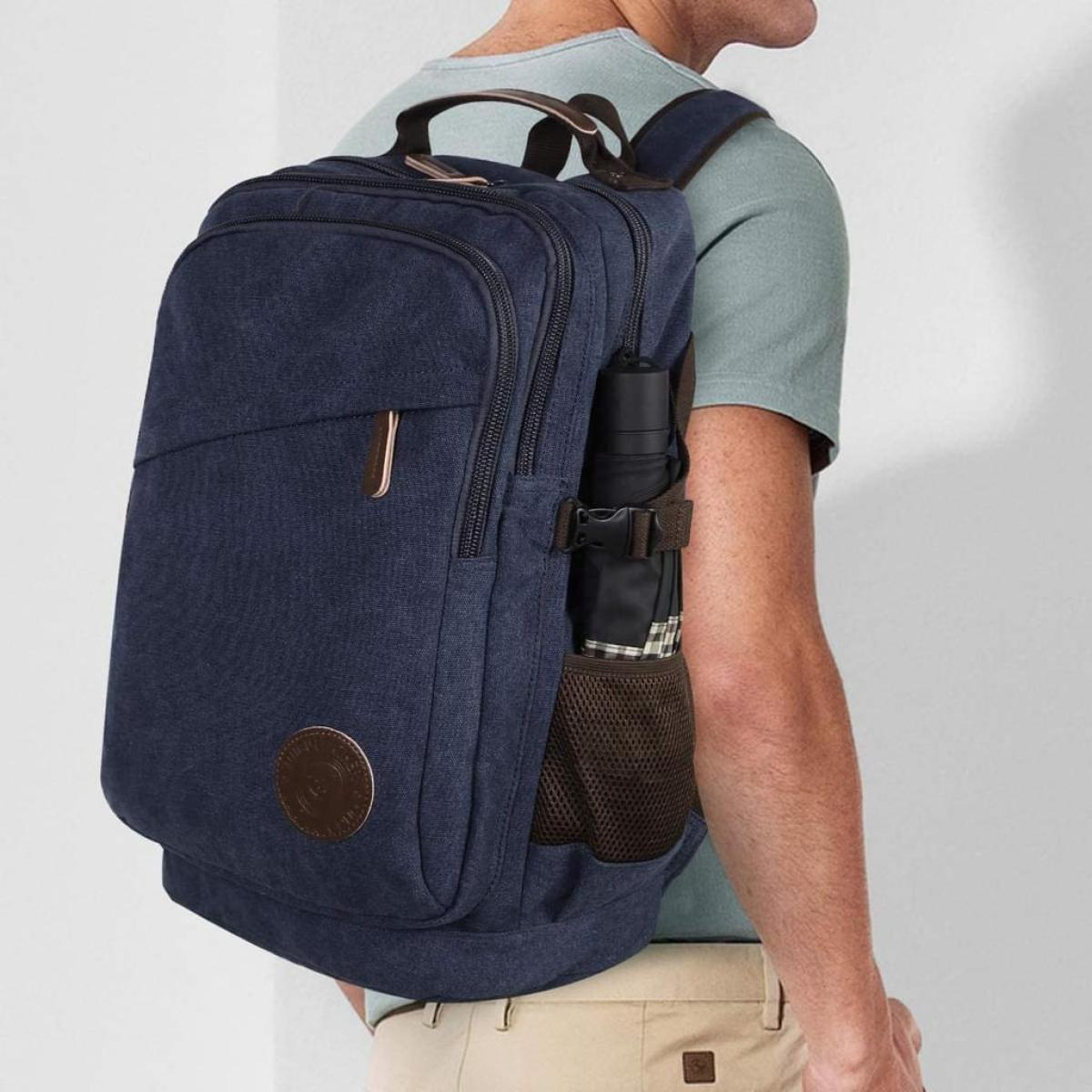 Ein marineblauer Rucksack mit braunen Lederdetails und einer Wasserflasche in der Seitentasche.