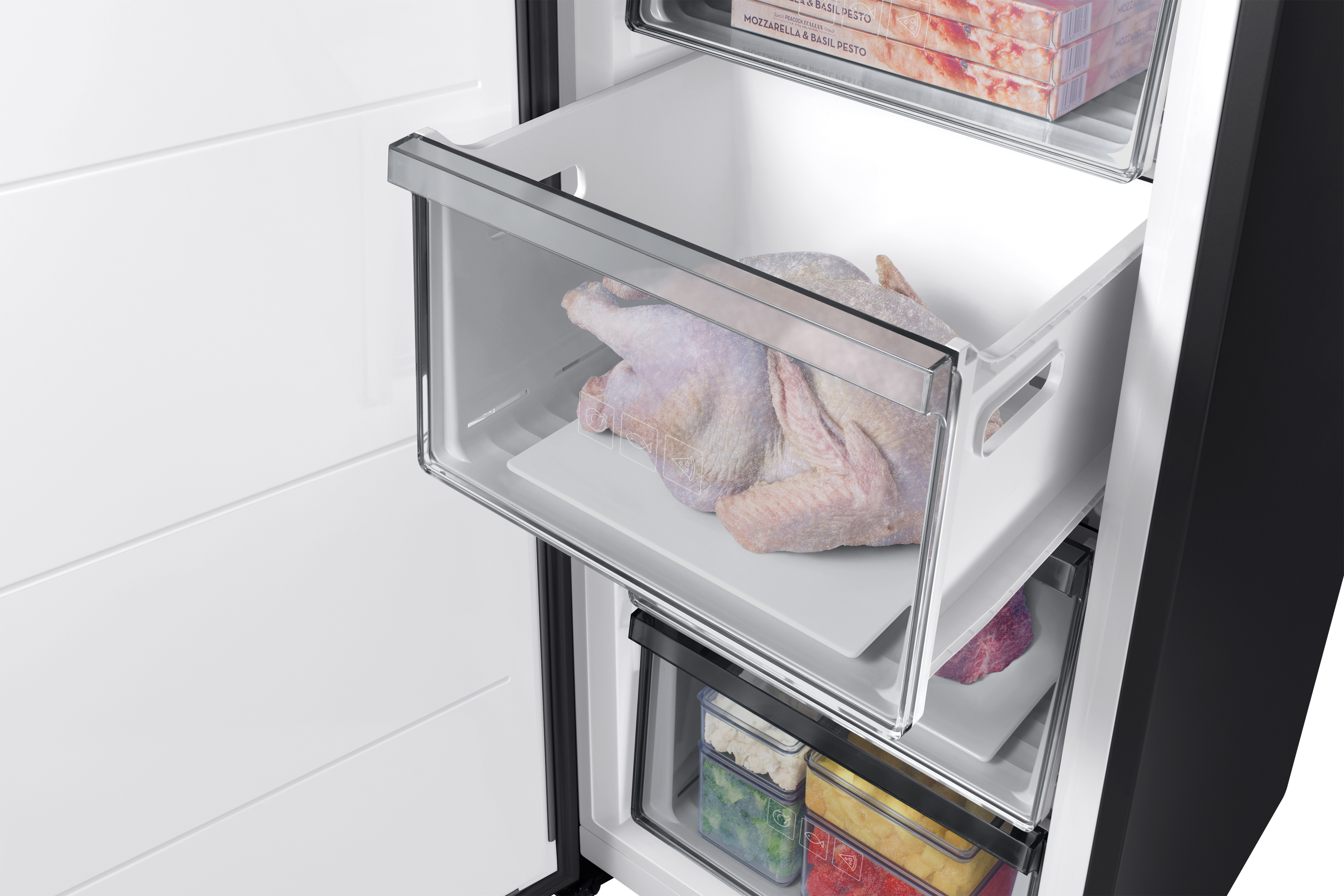 Wnętrze lodówki ma szufladę z surowym indykiem. Poniżej inne szuflady zamrażarki z mrożoną żywnością.