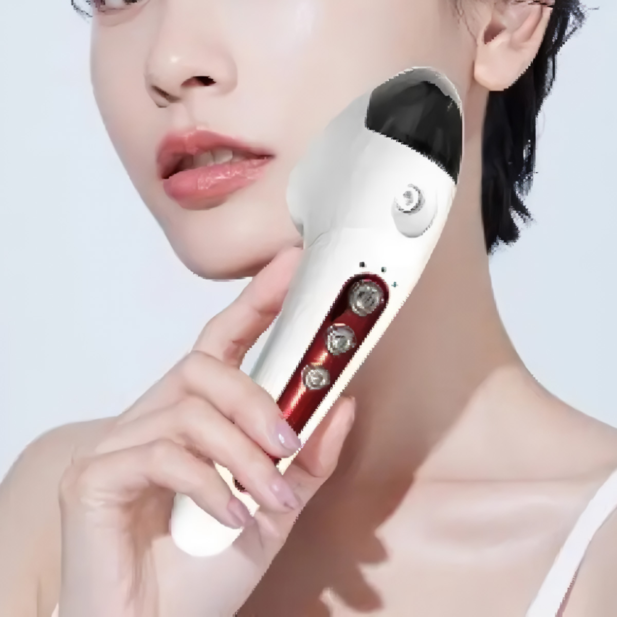 Una mujer sosteniendo un dispositivo de belleza blanco con luces rojas y una parte superior negra, cerca de su rostro.