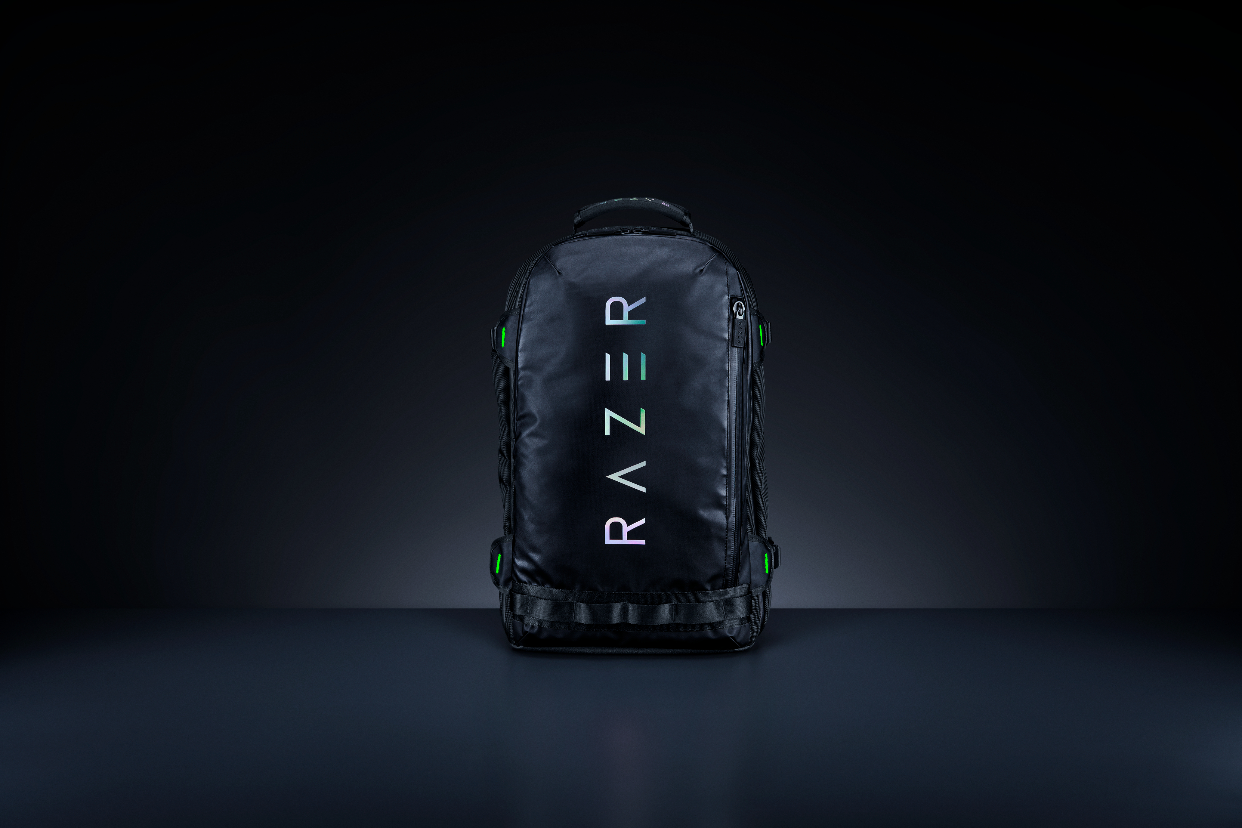 Ein schwarzer Razer-Rucksack mit dem Razer-Logo in Weiß und grünen Akzenten. Vor dunklem Hintergrund.