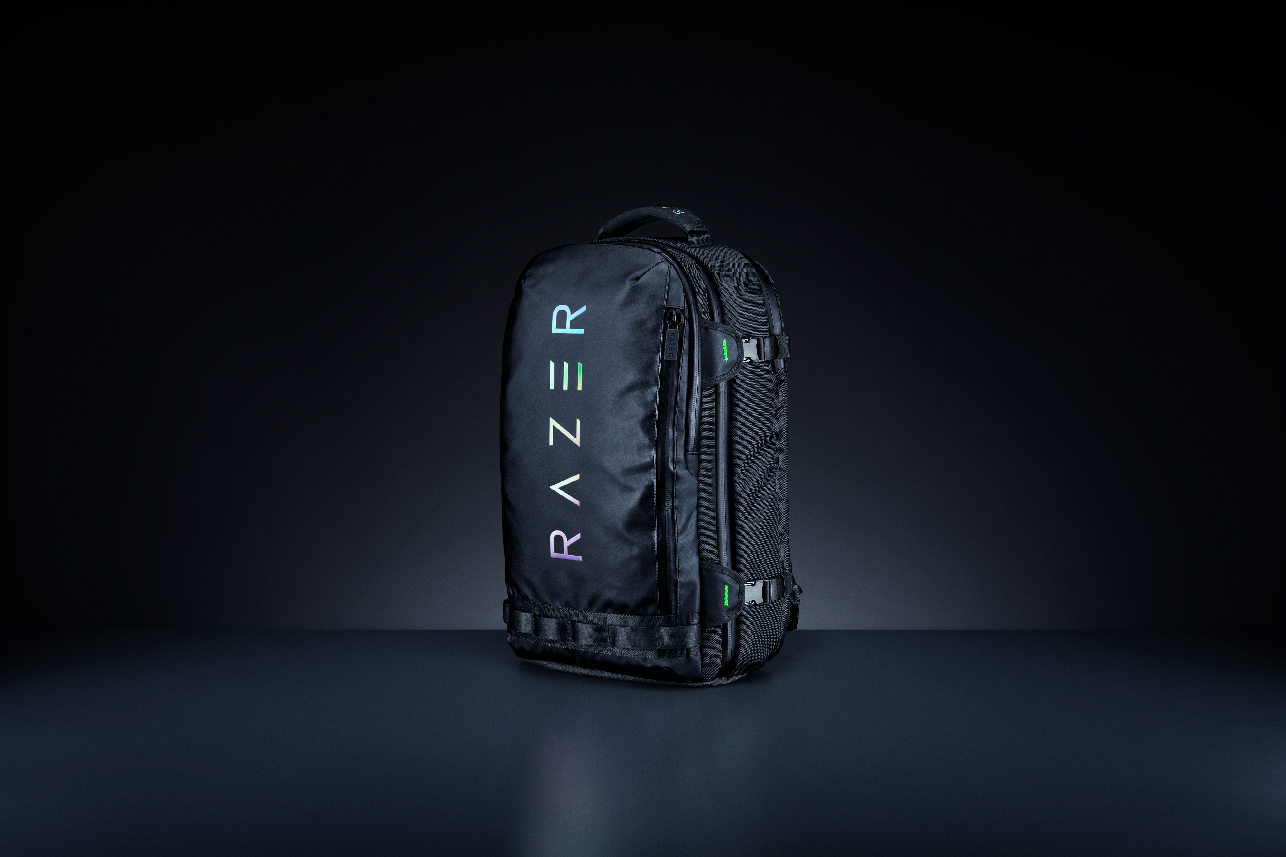 Schwarzer Razer-Rucksack mit weißem Logo. Die Tasche befindet sich auf einer dunklen Oberfläche mit dunklem Hintergrund.