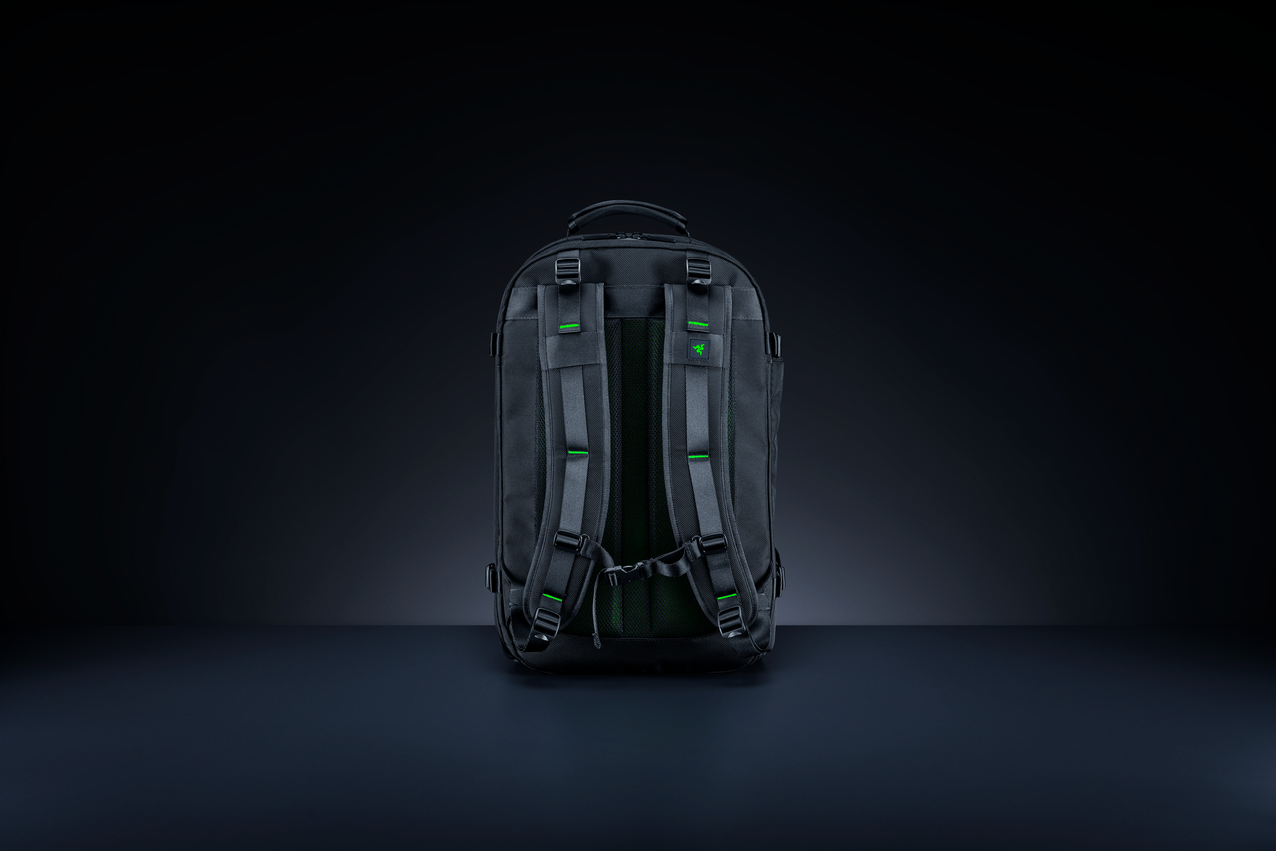 Schwarzer Razer-Rucksack auf dunkler Oberfläche. Merkmale: Gurte, grüne Akzente, Logo.