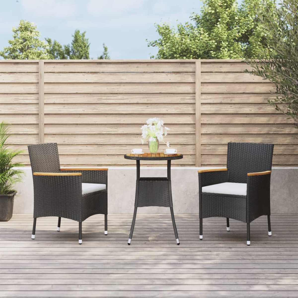 Essgruppe im Freien mit kleinem Tisch und zwei Stühlen auf einer Holzterrasse.