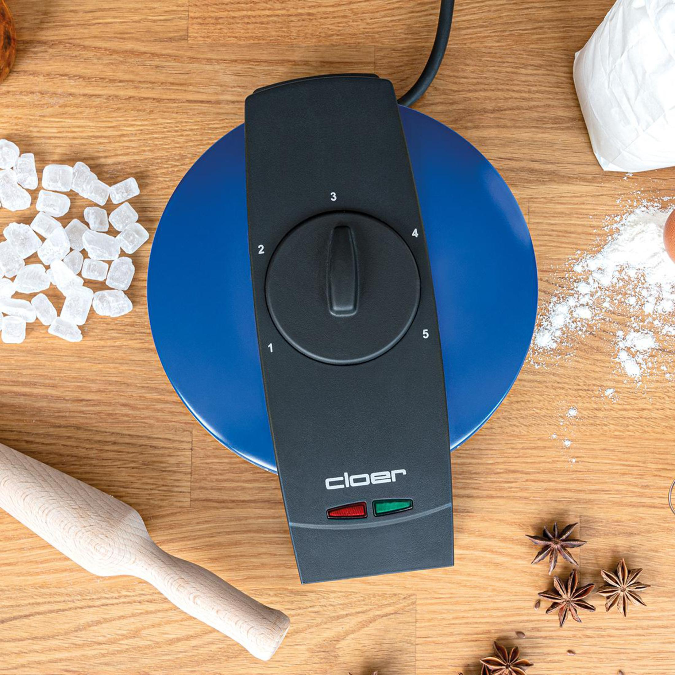 Macchina per waffle su un tavolo di legno con ingredienti.