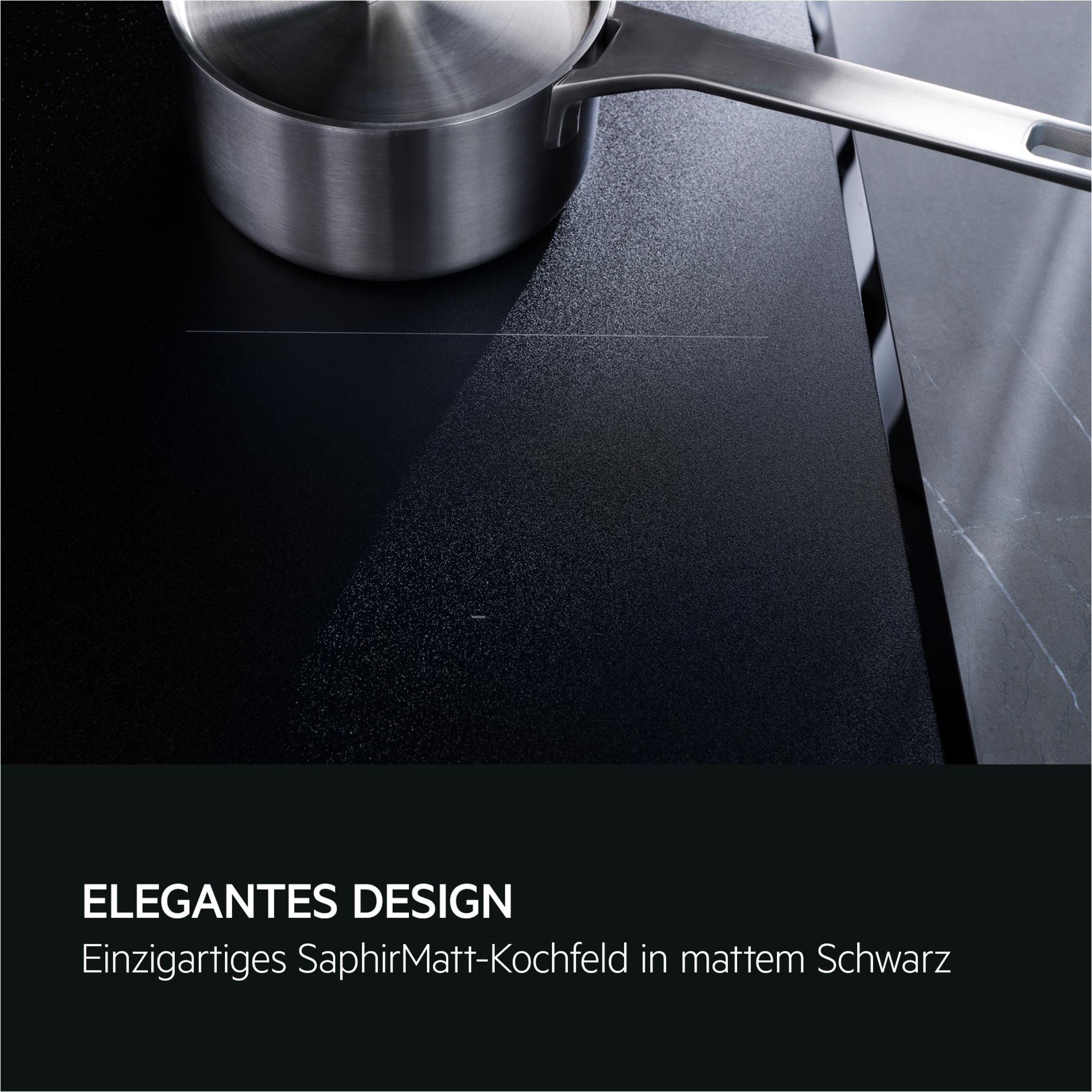 Gros plan sur une table de cuisson à induction noire avec une casserole en acier inoxydable.