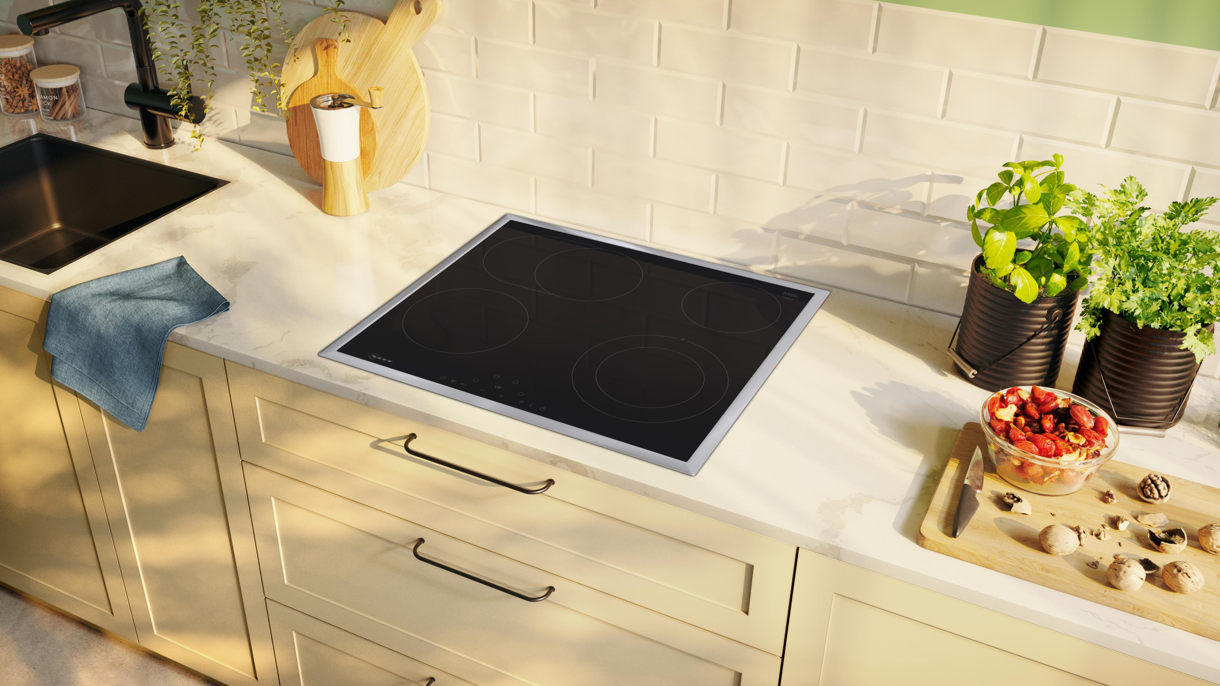 Piano cucina con piano cottura a induzione e vari oggetti da cucina.