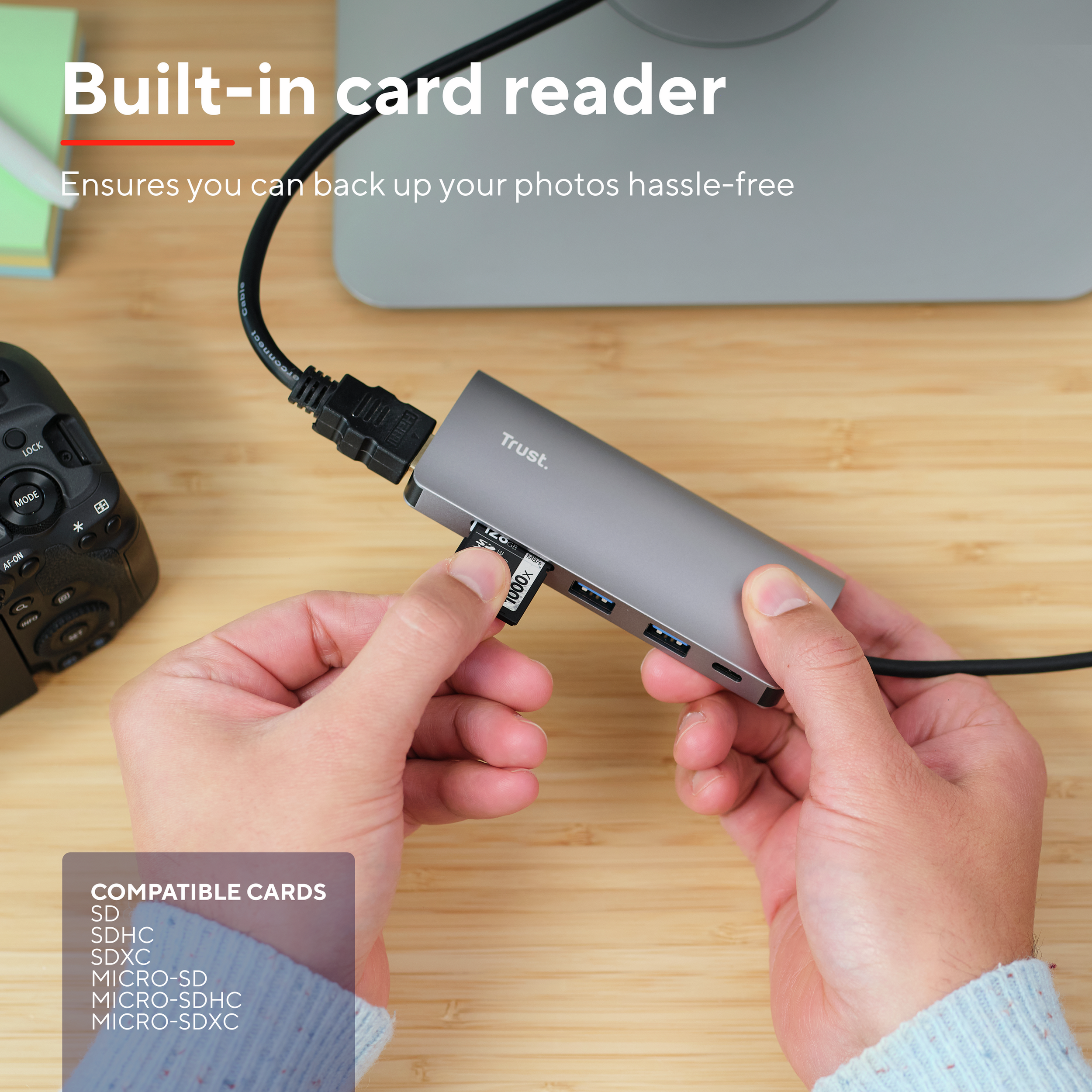 Eine Person, die eine Speicherkarte an einen USB-Hub anschließt. Der Hub ist an einen Monitor angeschlossen.