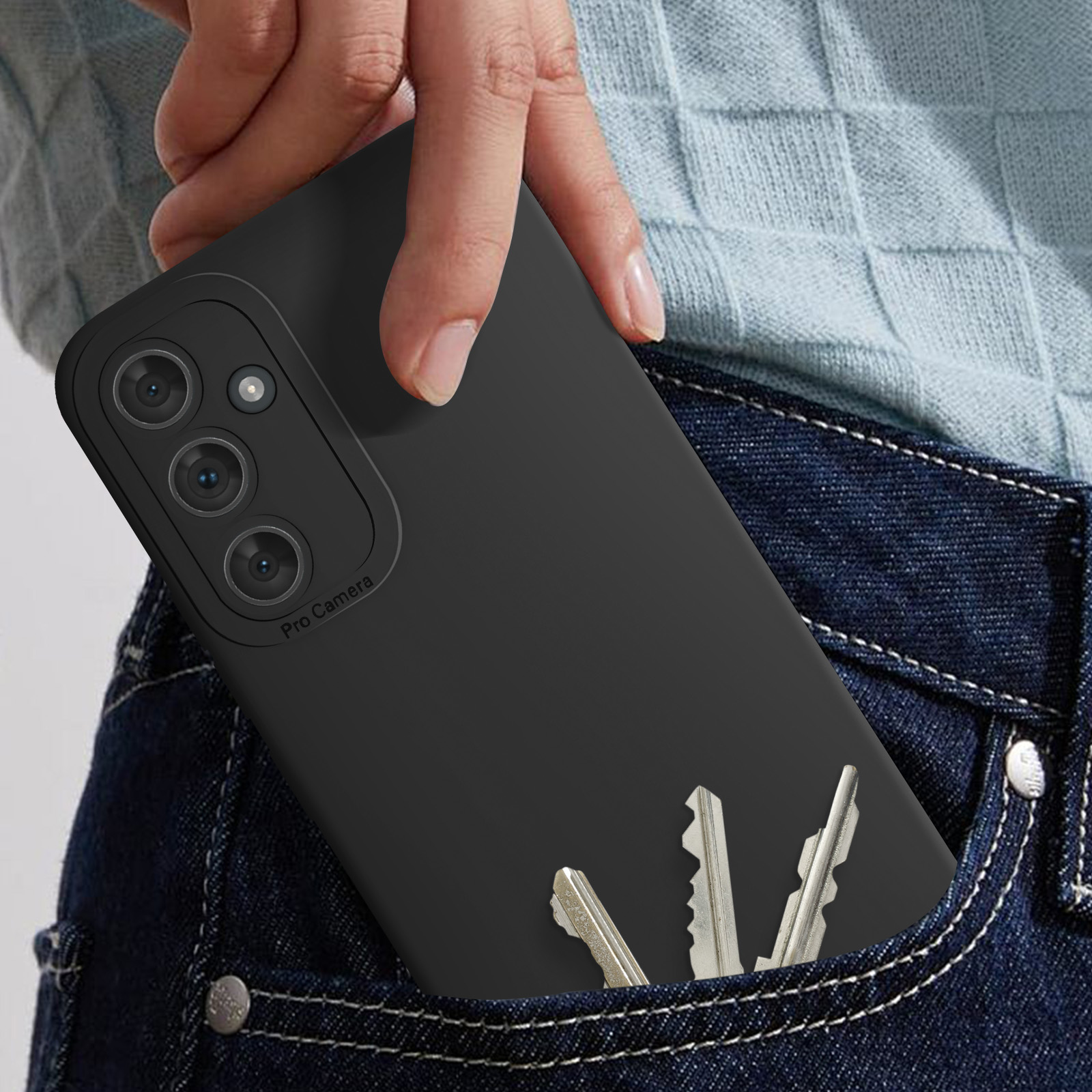 Mano in tasca che tiene un telefono nero e chiavi. Tasca dei jeans con chiavi.