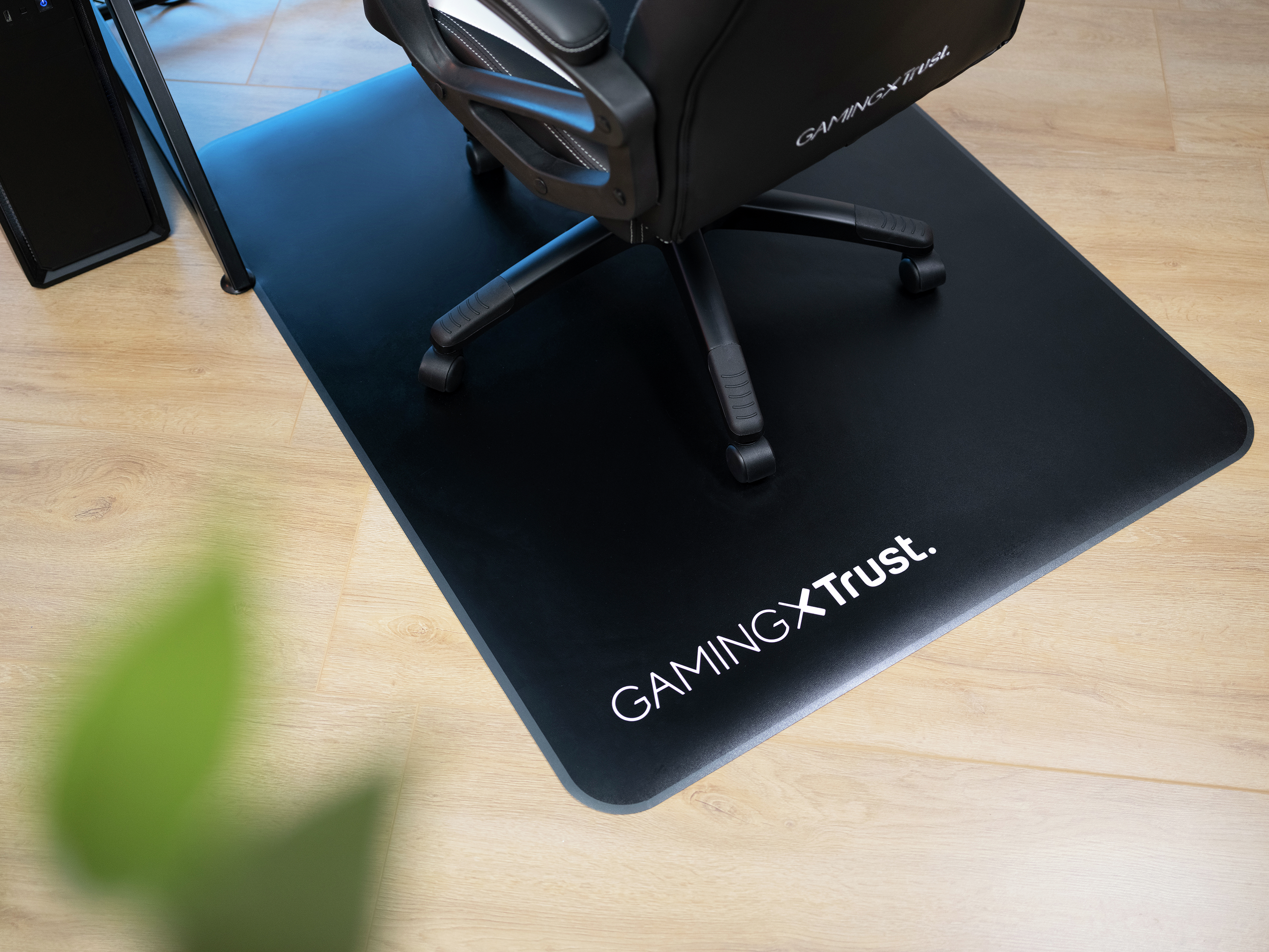 Gaming-Stuhl und -Matte auf Holzboden, Logo sichtbar.