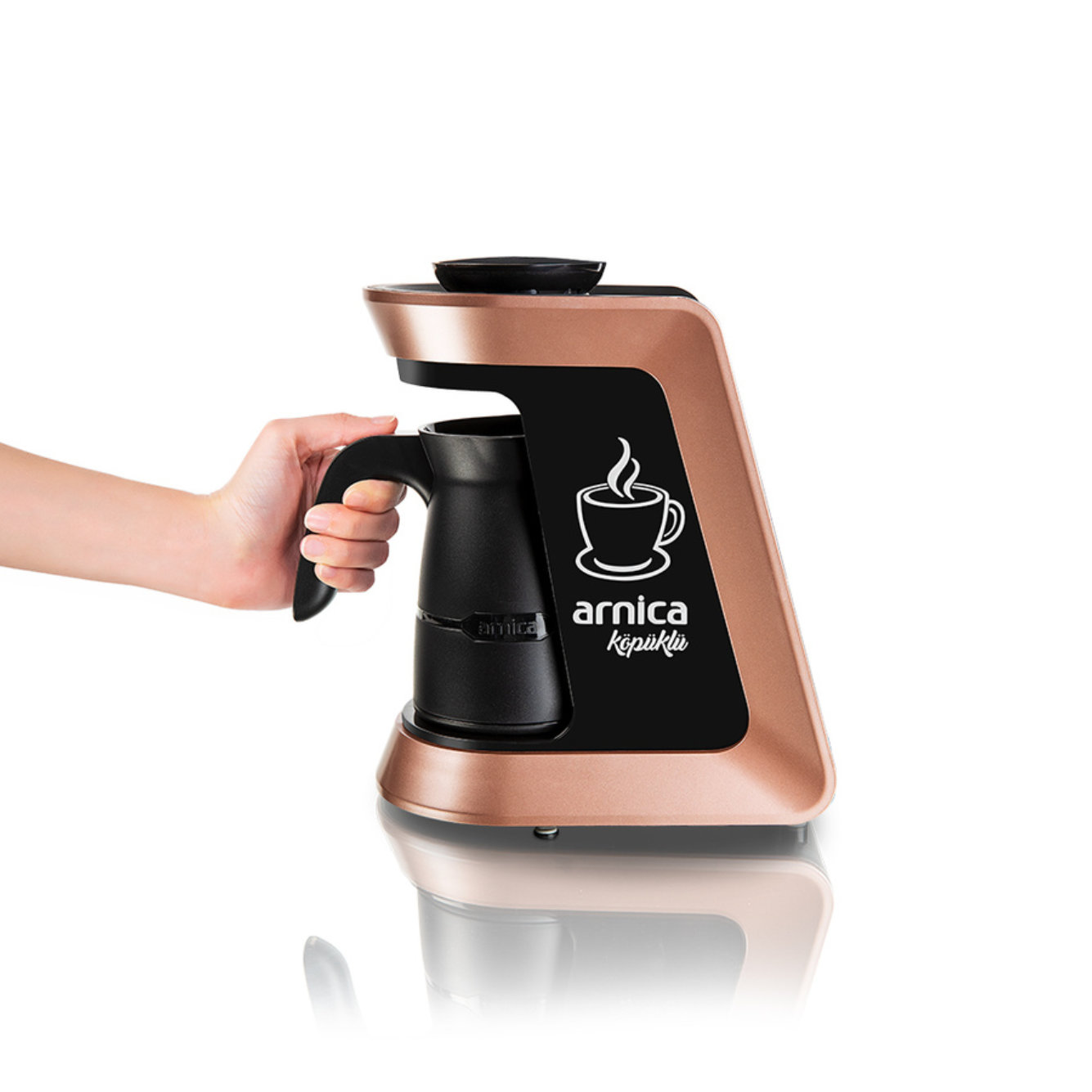 Eine Hand hält eine schwarze Kaffeemaschine mit roségoldenem Finish, mit dem Logo 'arnica köpüklü'.