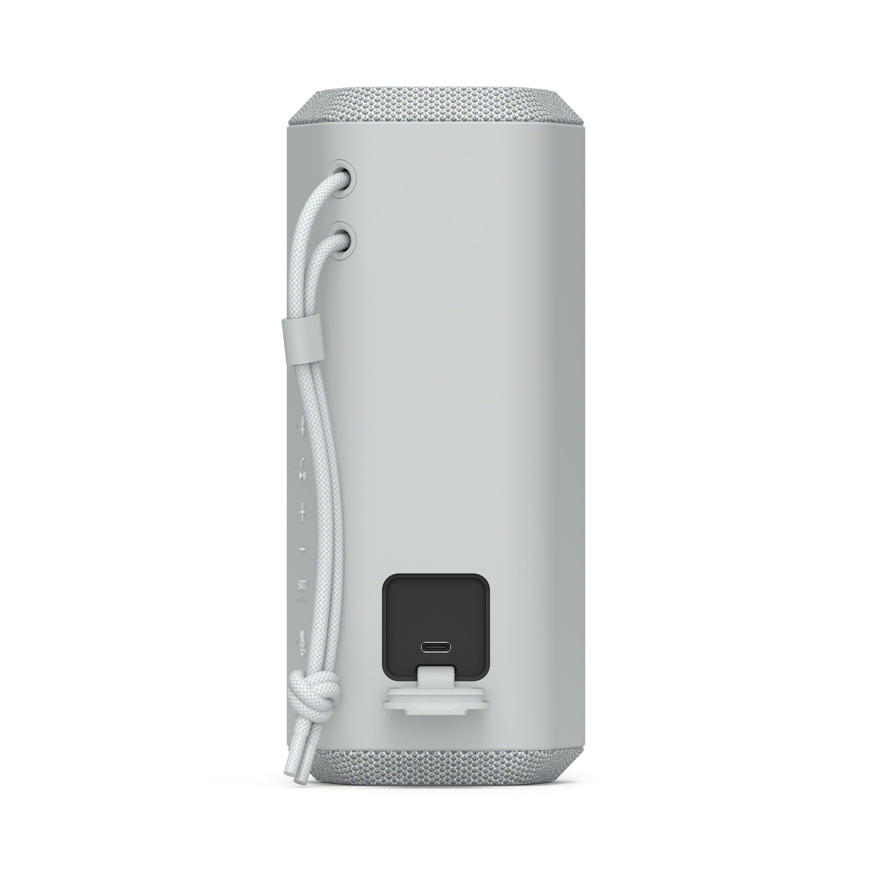 Altavoz gris portátil con cable blanco, puerto USB.