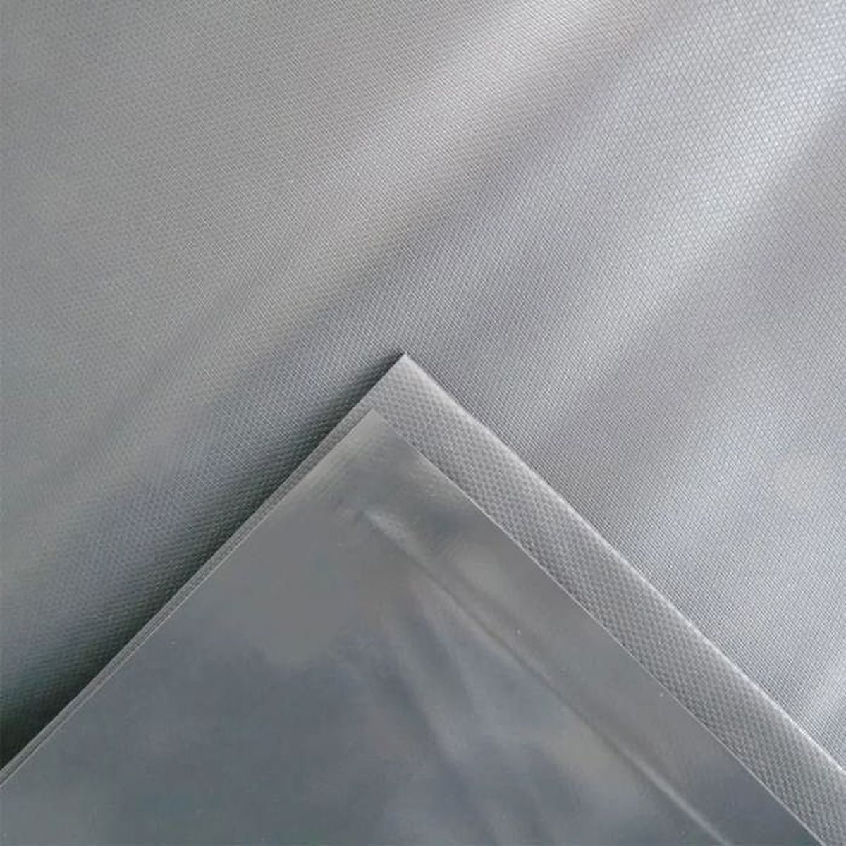 Eine Folie aus klarem Kunststoff auf einem grauen Stoff.