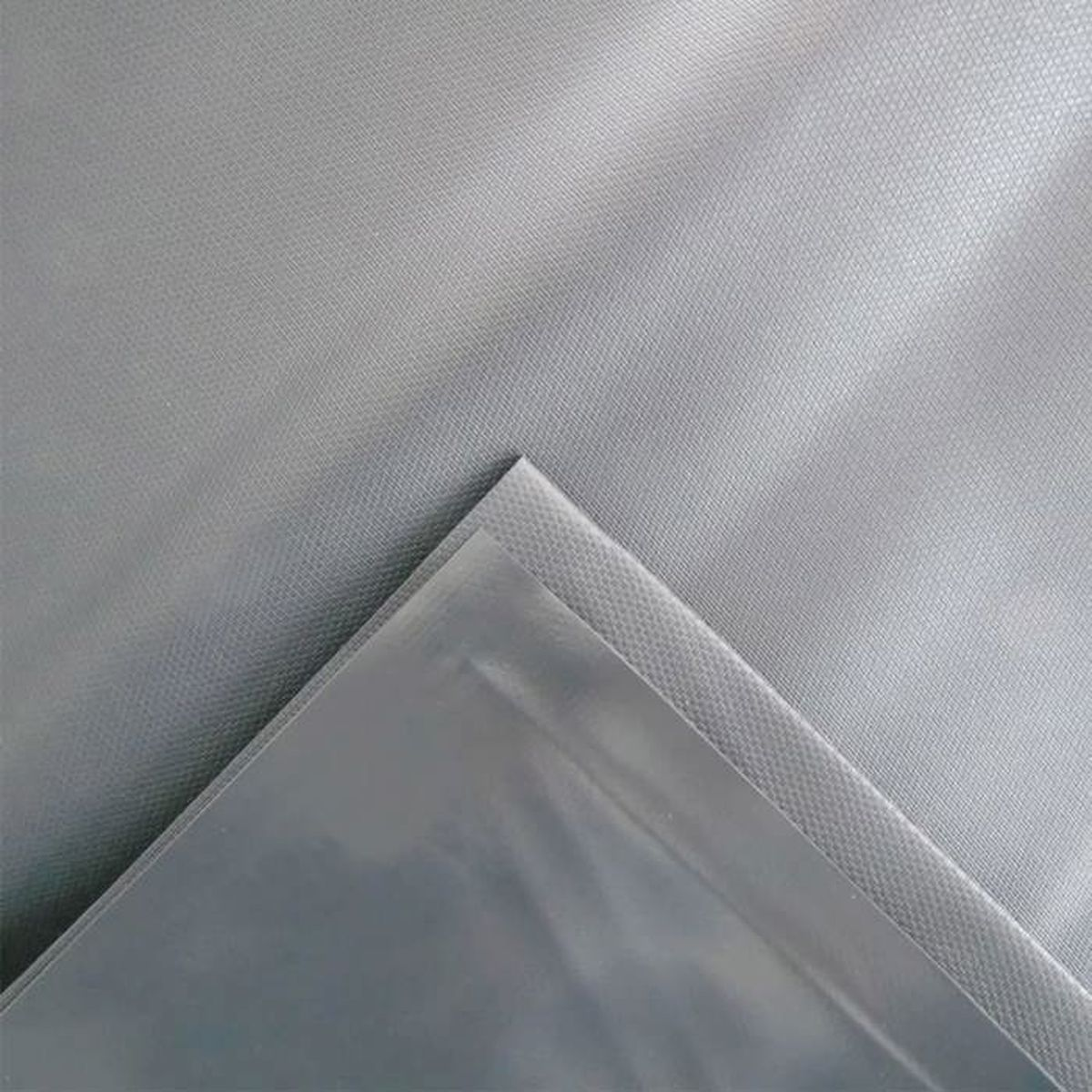 Nahaufnahme eines grauen Stoffes, Ecke gefaltet. Die Textur ist sichtbar.