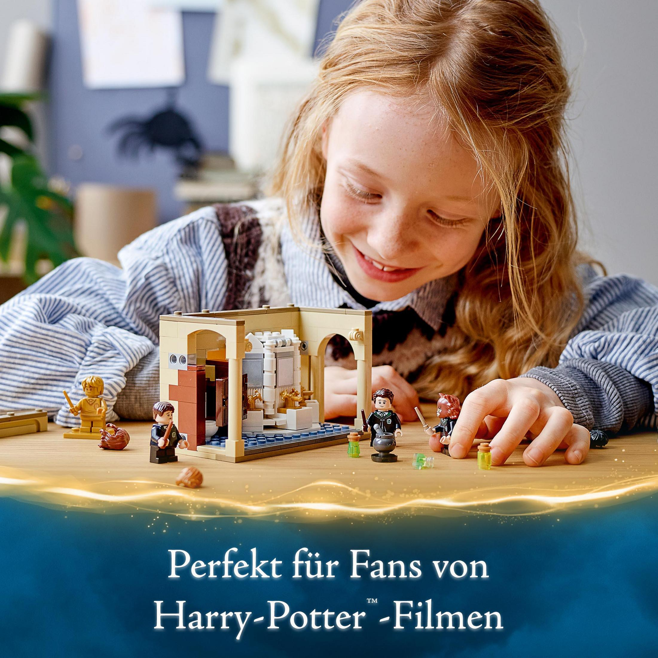 Ein Mädchen lächelt über ein Harry Potter Lego Set mit Minifiguren und Requisiten.