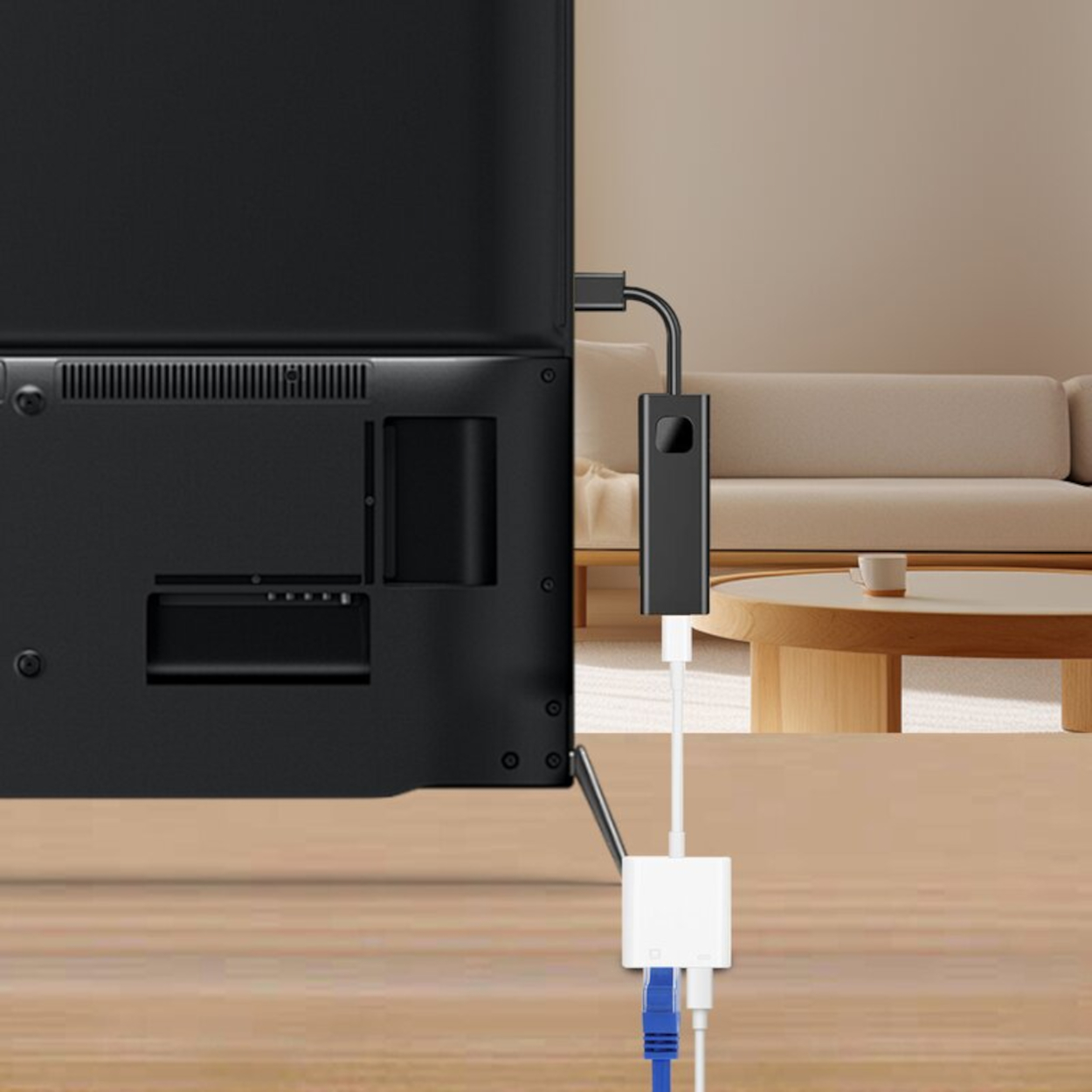 Schwarzer Adapter, der an einen Fernseher angeschlossen ist. Weiße und blaue Kabel sind eingesteckt.