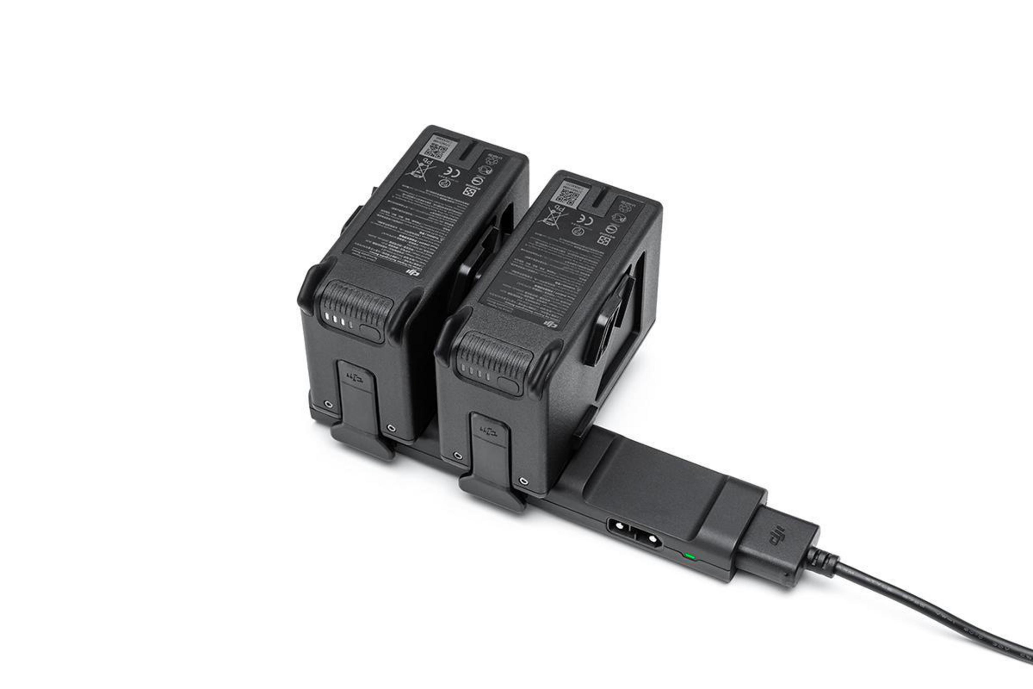 Czarne baterie do drona i ładowarka na białym tle.