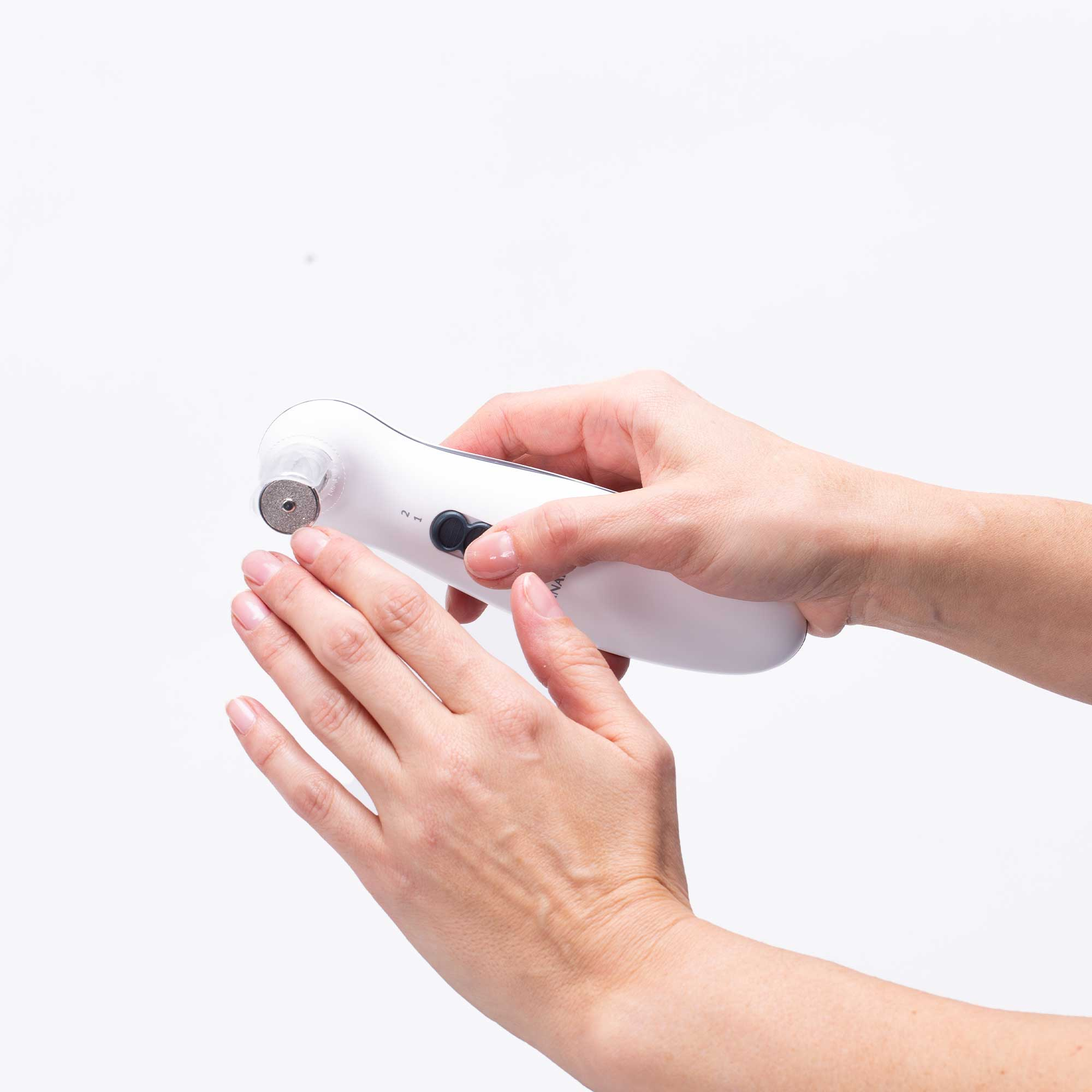 Dłonie trzymające białe urządzenie do pielęgnacji paznokci z obracającą się głowicą.