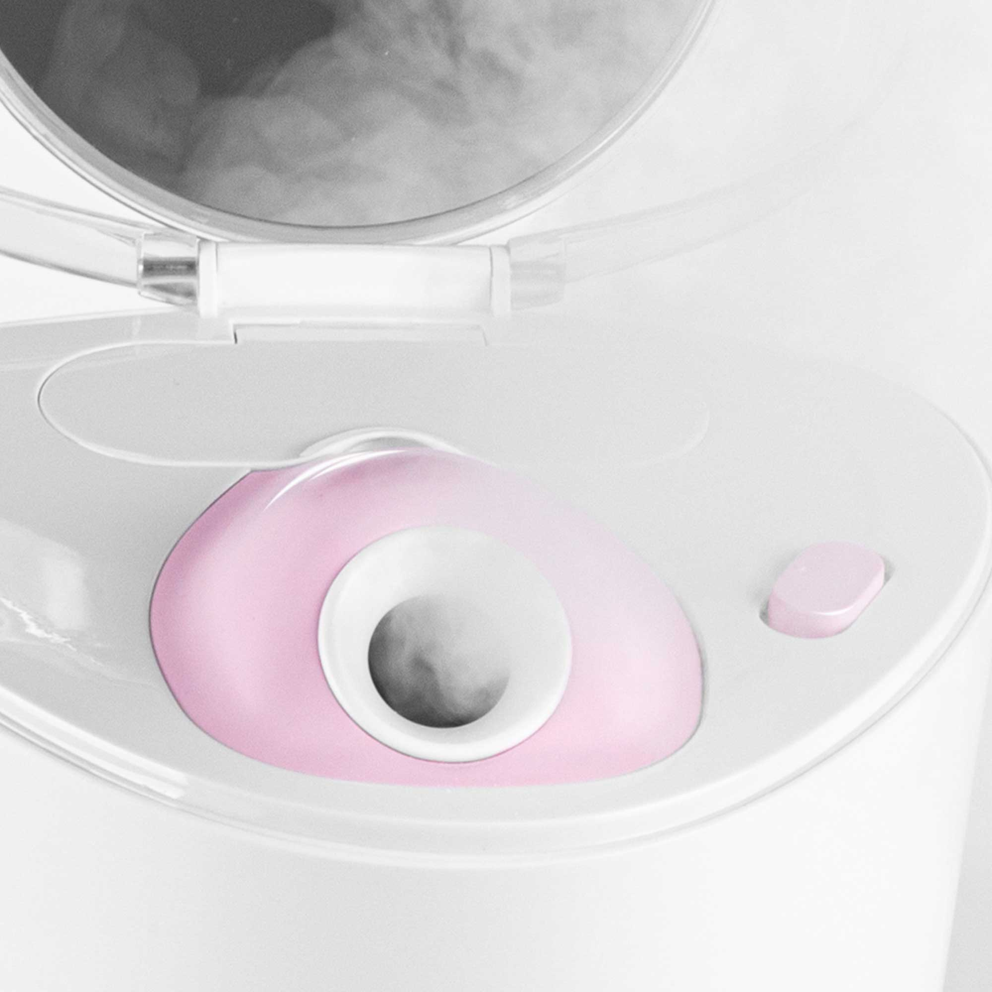 Close-up of a pink facial steamer with steam emitting from the center and an open lid.