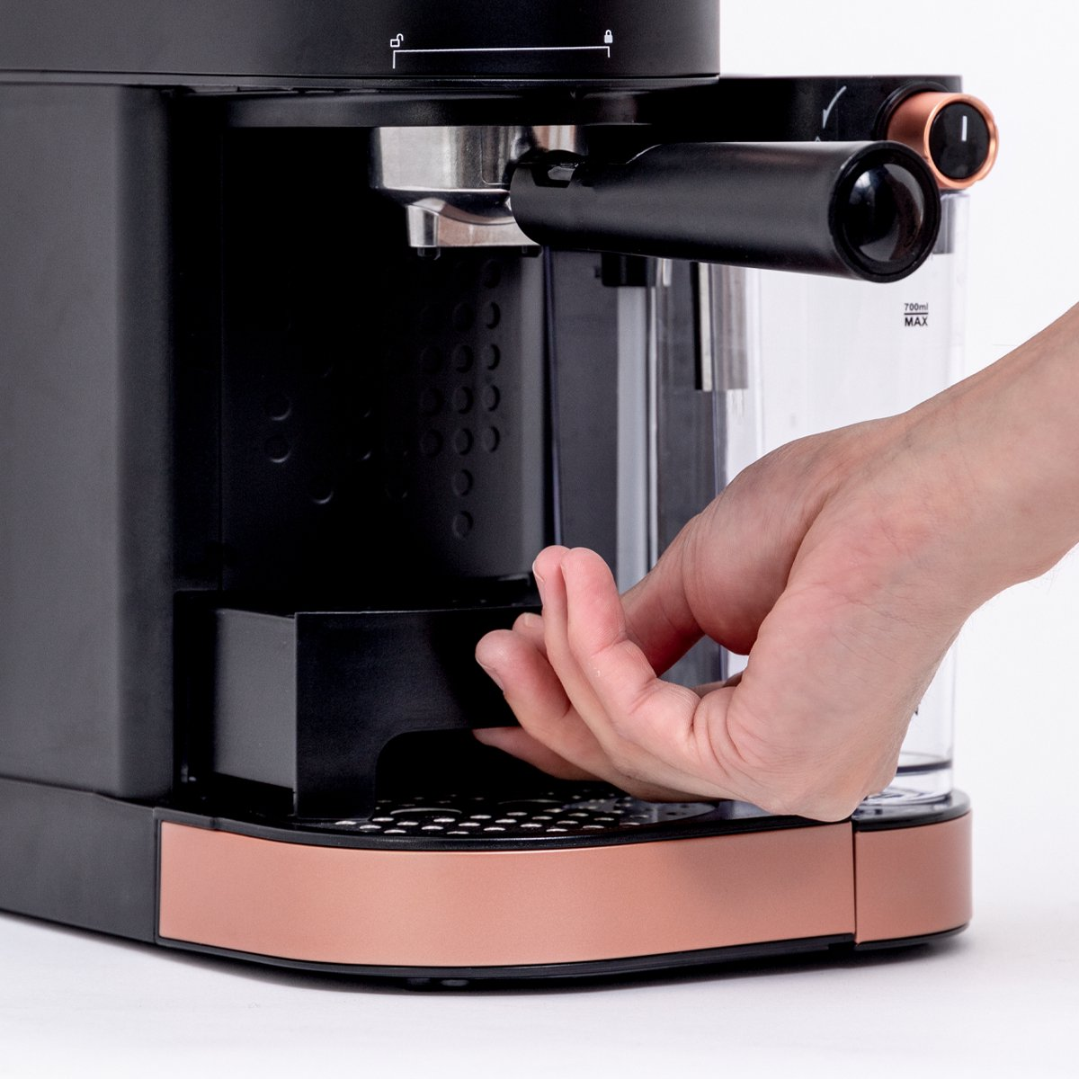 Person's hand reaching to a black and copper espresso machine, close-up.