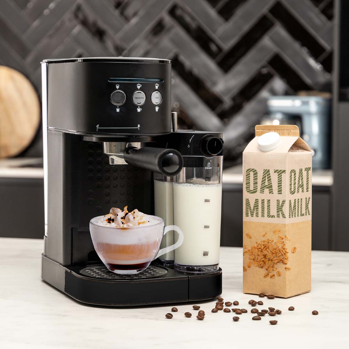 A black espresso machine with a cappuccino in a glass cup. A milk carton and coffee beans are next to it.