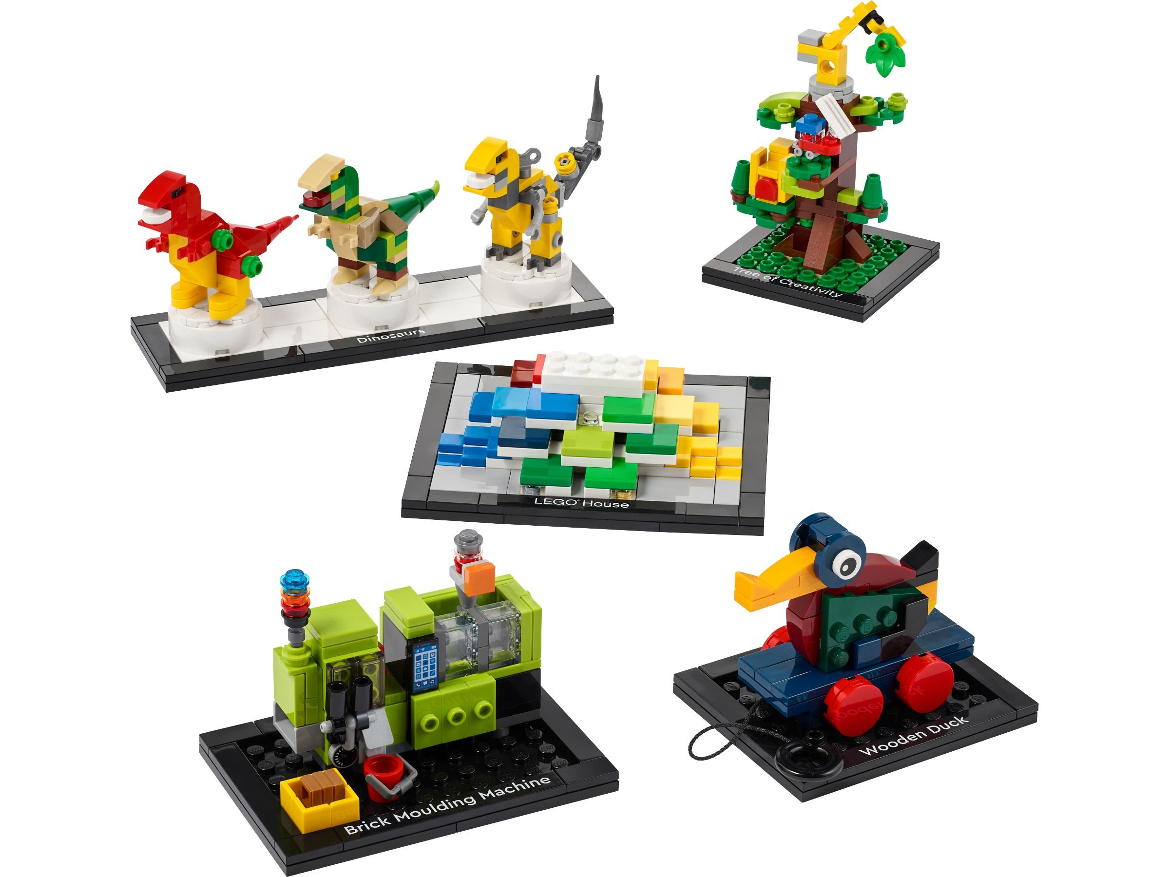 Verschiedene LEGO-Modelle auf schwarzen Sockeln: Dinosaurier, ein Haus, eine Ziegelmaschine und eine Holzente.